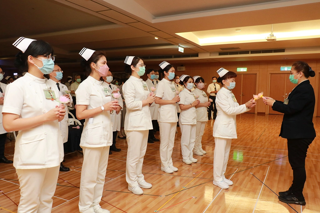莊淑婷副院長（右）、張梅芳主任（右二 ）將代表「薪火相傳」的心燈傳給同仁。