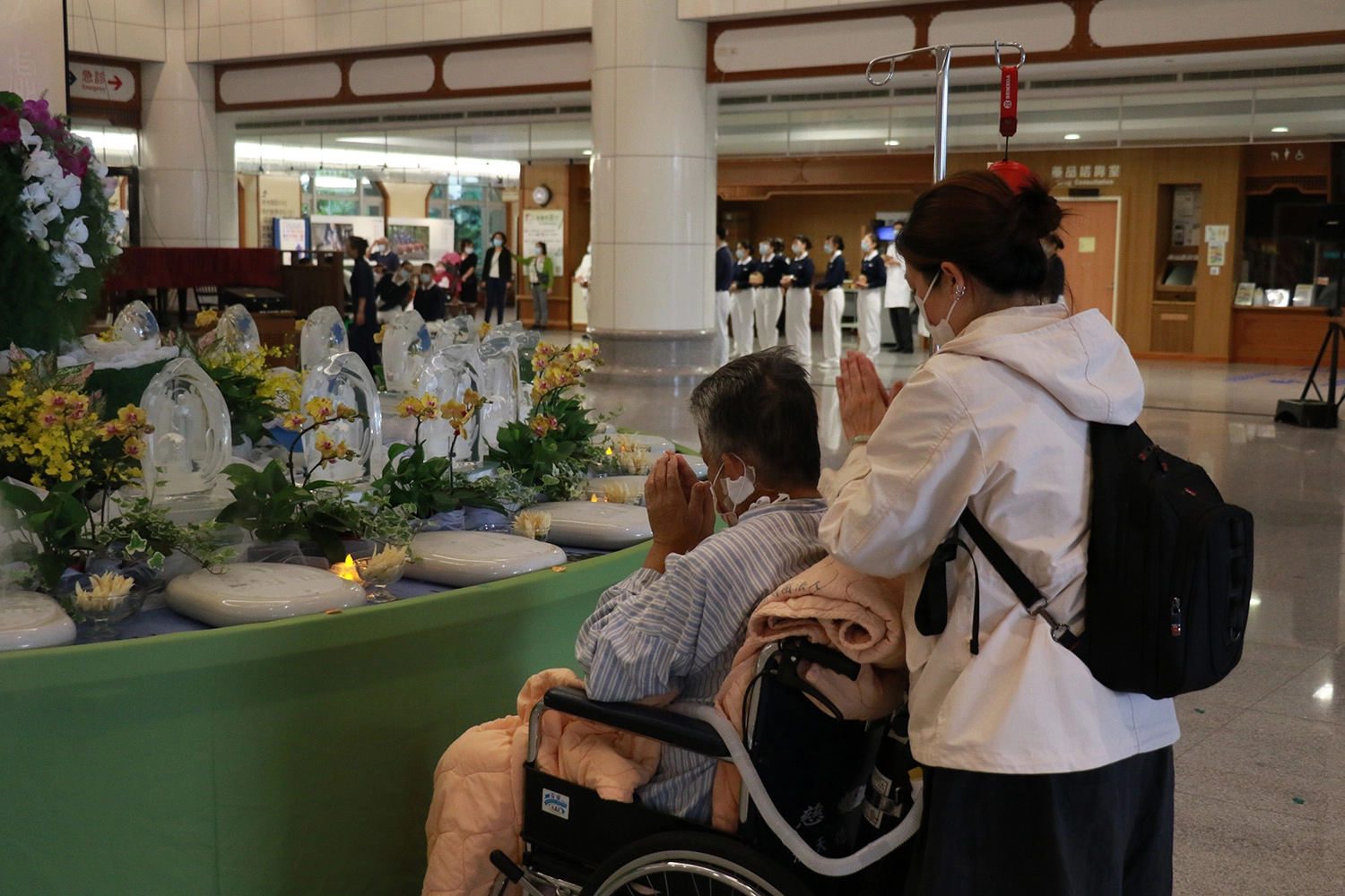 病人李先生(左一)在輪椅上參與浴佛，祈願早日康復。