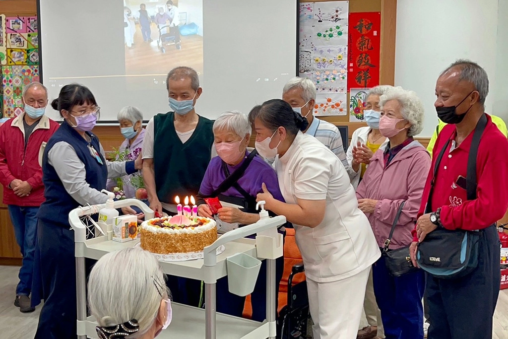 失智共照中心團隊為楊奶奶慶祝百歲生日，祝福她康復後可以再回來與共照中心的老師和同學們一起上課。