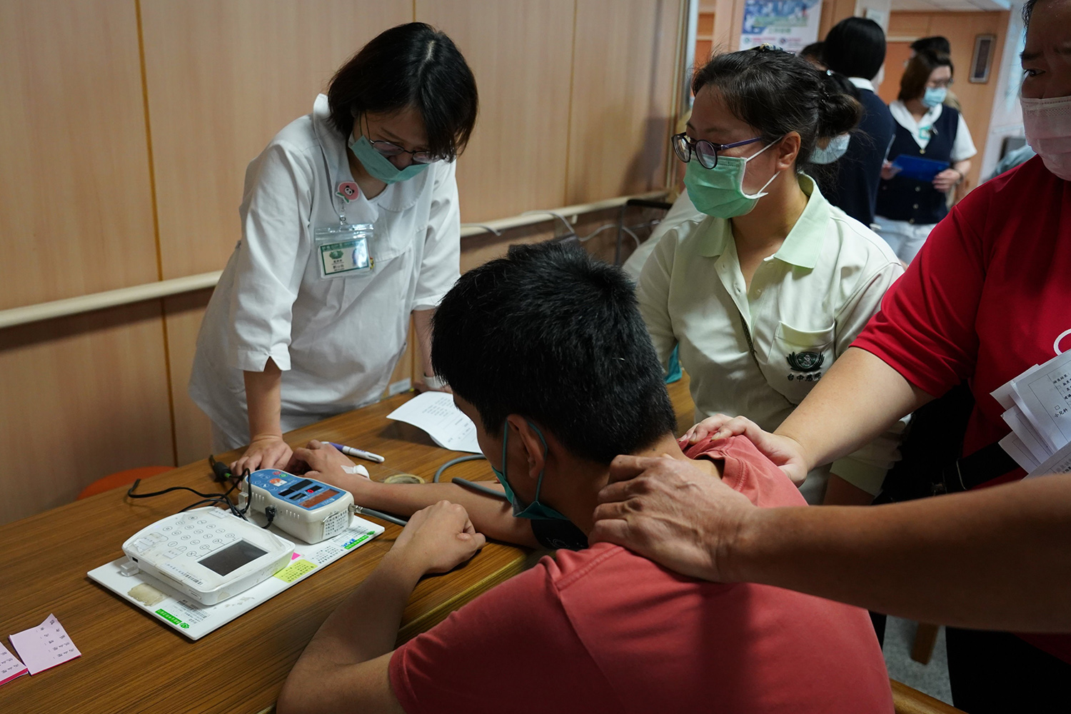 身懷六甲的門診護理師劉心怡（左）貢獻一己之力為院生量血壓。