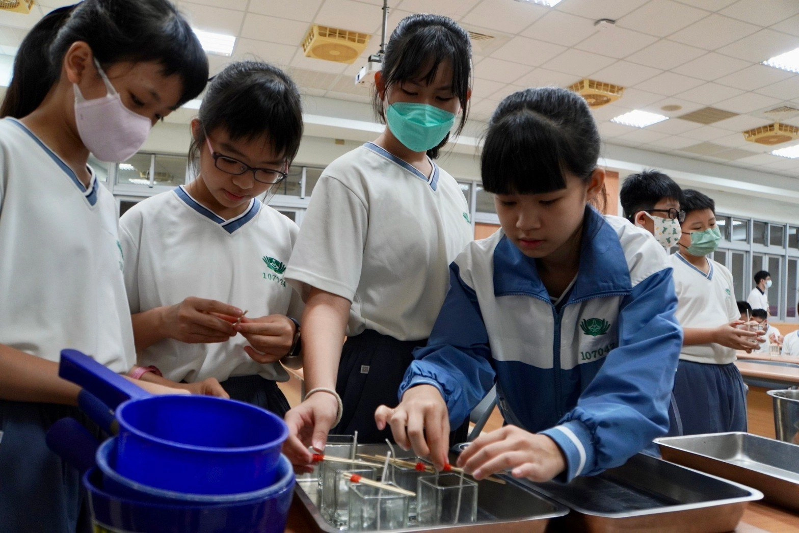 學生小心翼翼的操作製作香氛蠟燭的步驟。