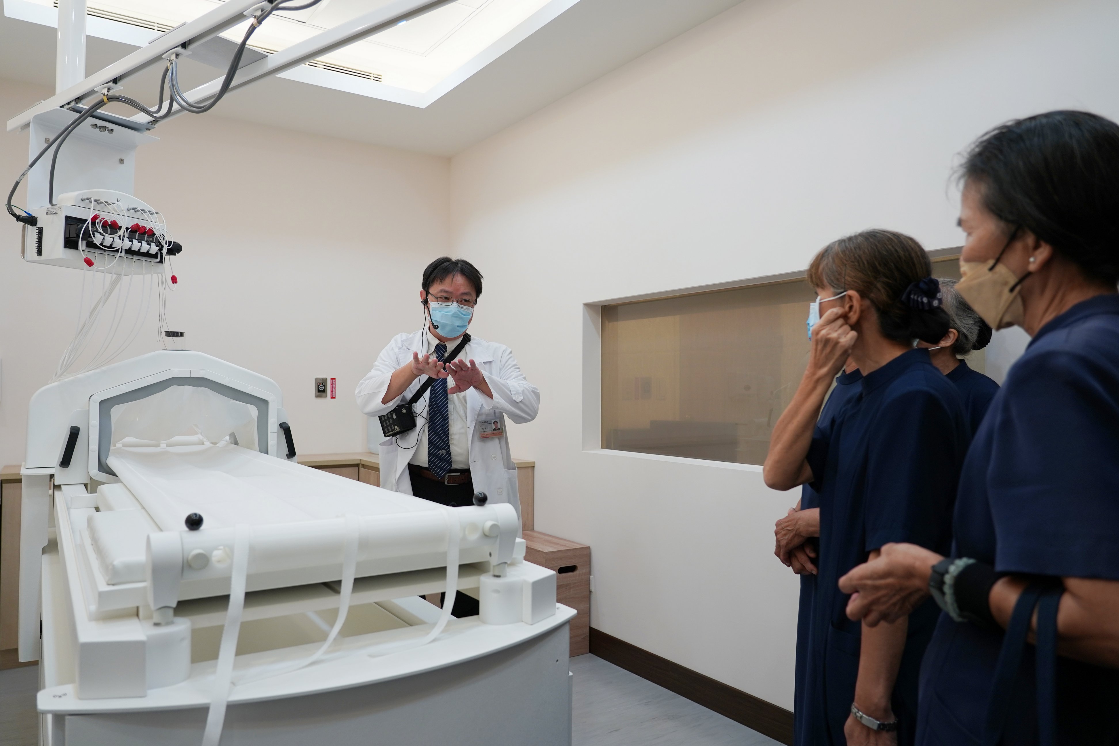 台中慈院放射腫瘤科主任陳冠文（左）在啟用典禮結束後導覽高階熱治療中心。