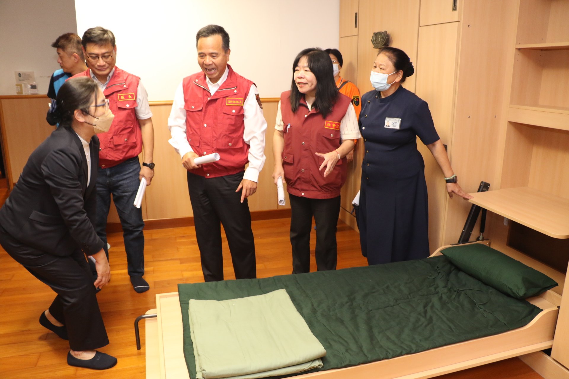 慈濟基金會災防組長劉秋伶(左1)為眾人介紹多功能油壓床使用。