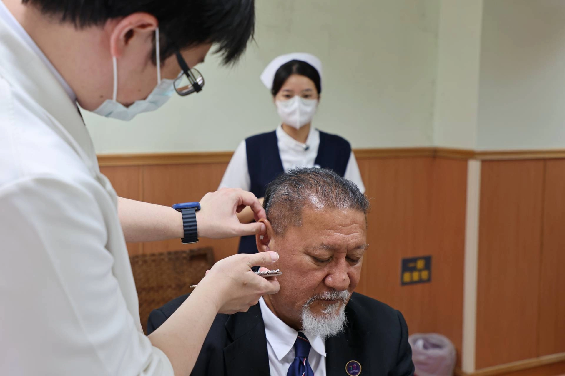 陳中奎醫師為Isaia Taape部長貼耳豆。