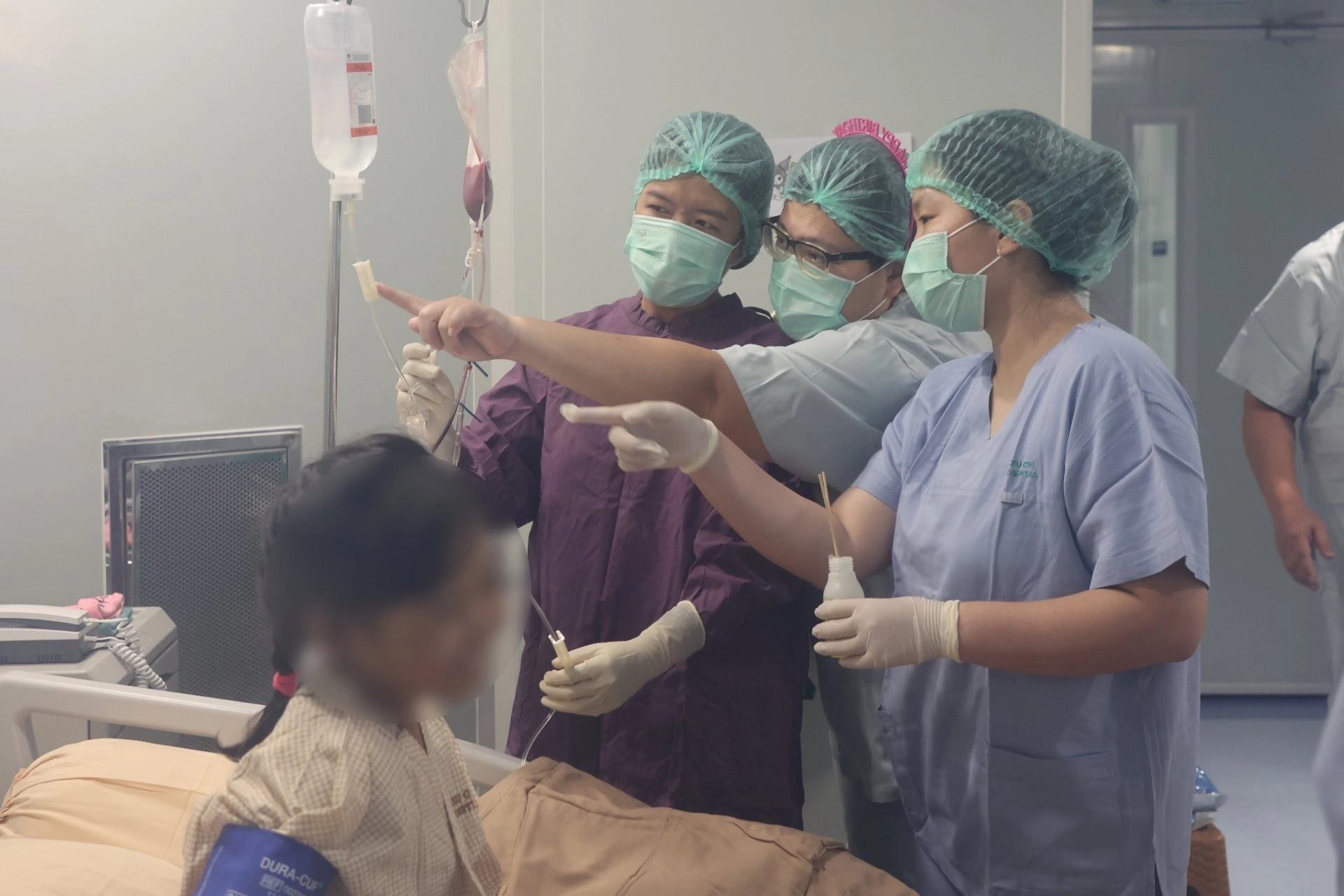 小兒暨骨髓移植病房護理長李依蓉(中)，正在與印尼慈院護理團隊進行骨髓輸注前的叮嚀。