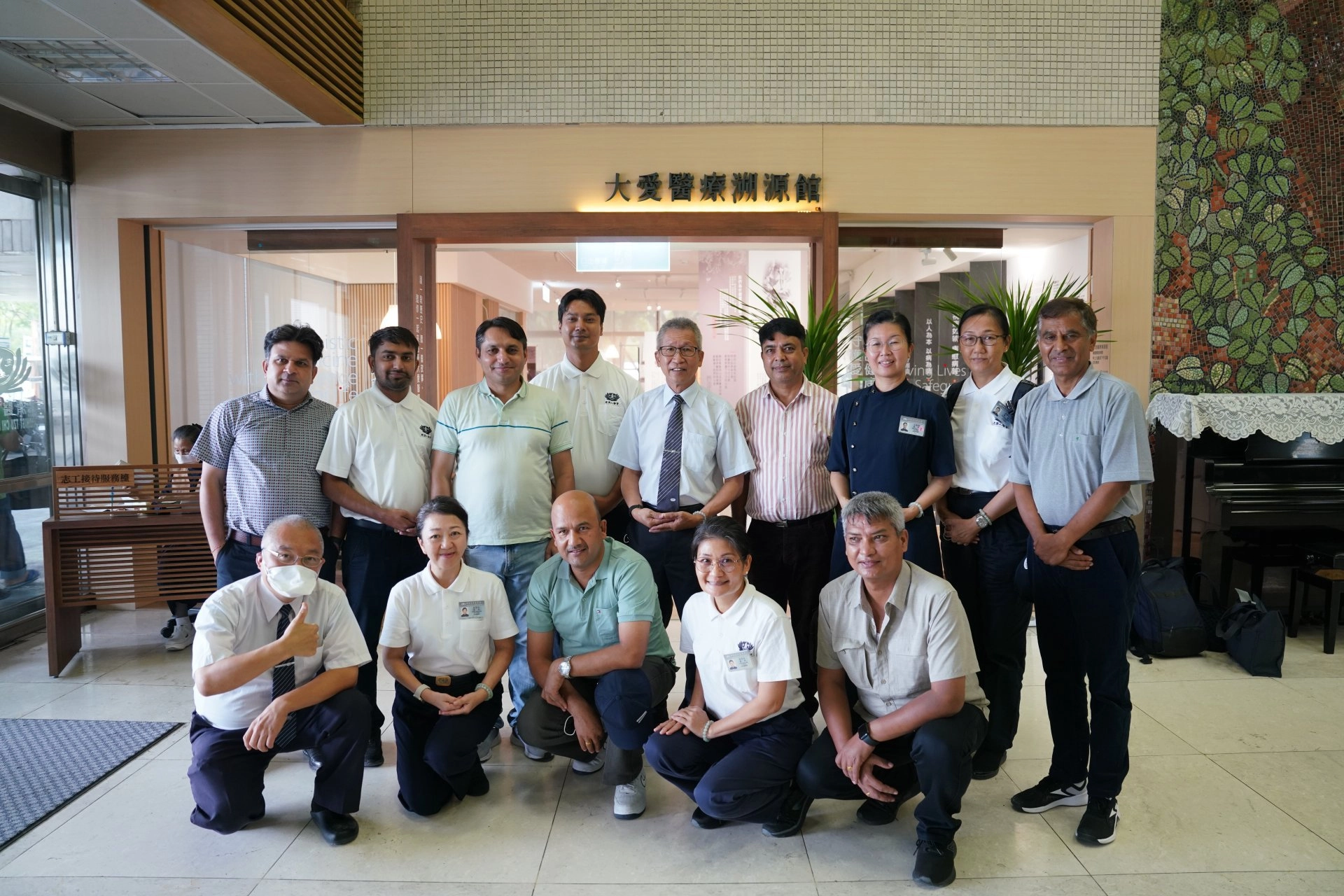 參訪大愛醫療溯源館，尼泊爾衛生醫療團與陳吉民醫師(後排右五)、李彝邦醫師(前排左一)在館前合影。