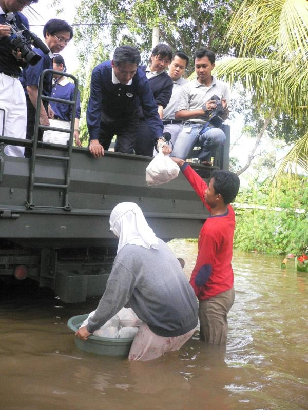 印尼雅加達水災淹水嚴重，何日生為志工於大卡車上發放物資。