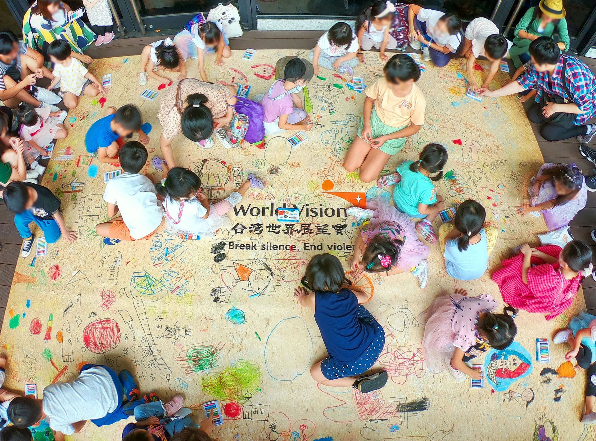全場大小朋友在地板上自由聯合作畫，童言童語地寫下祝福。