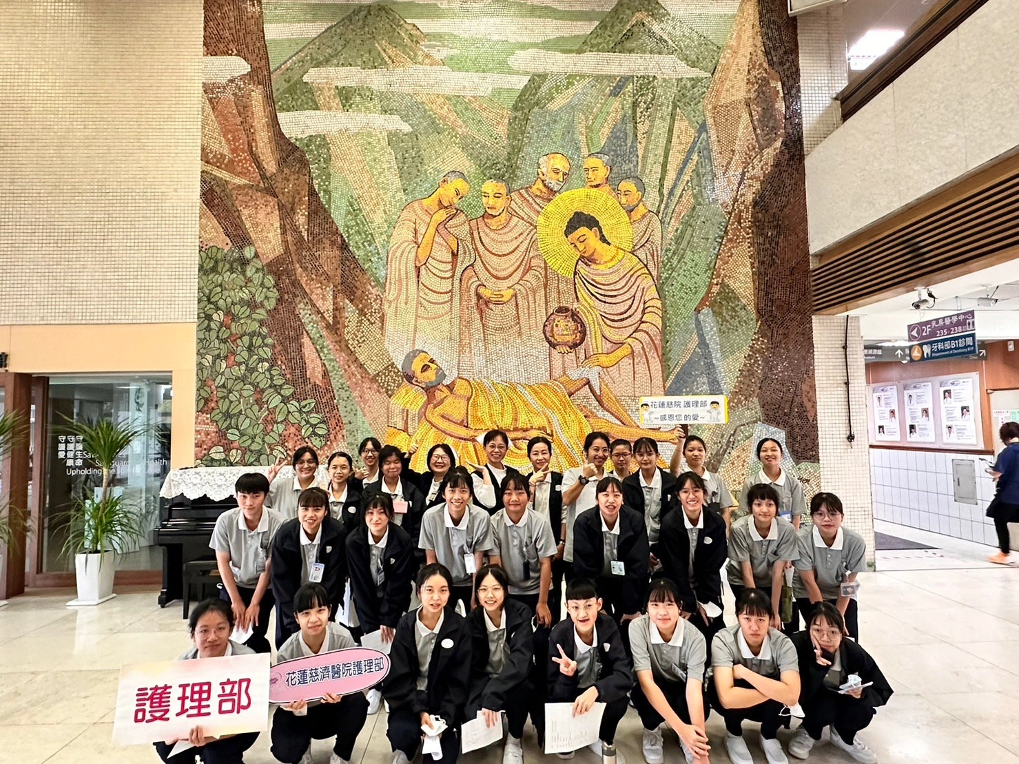 花蓮慈院與慈科大開辦護理職場體驗，幫助五專、四技二年級新生，先認識醫院環境，慈科大護理系助理教授洪玉龍(後排右六)、花蓮慈院護理部副主任呂基燕(後排右七)、張智容督導(後排右八)與臨床護理師與學弟妹在佛陀問病圖前合影。