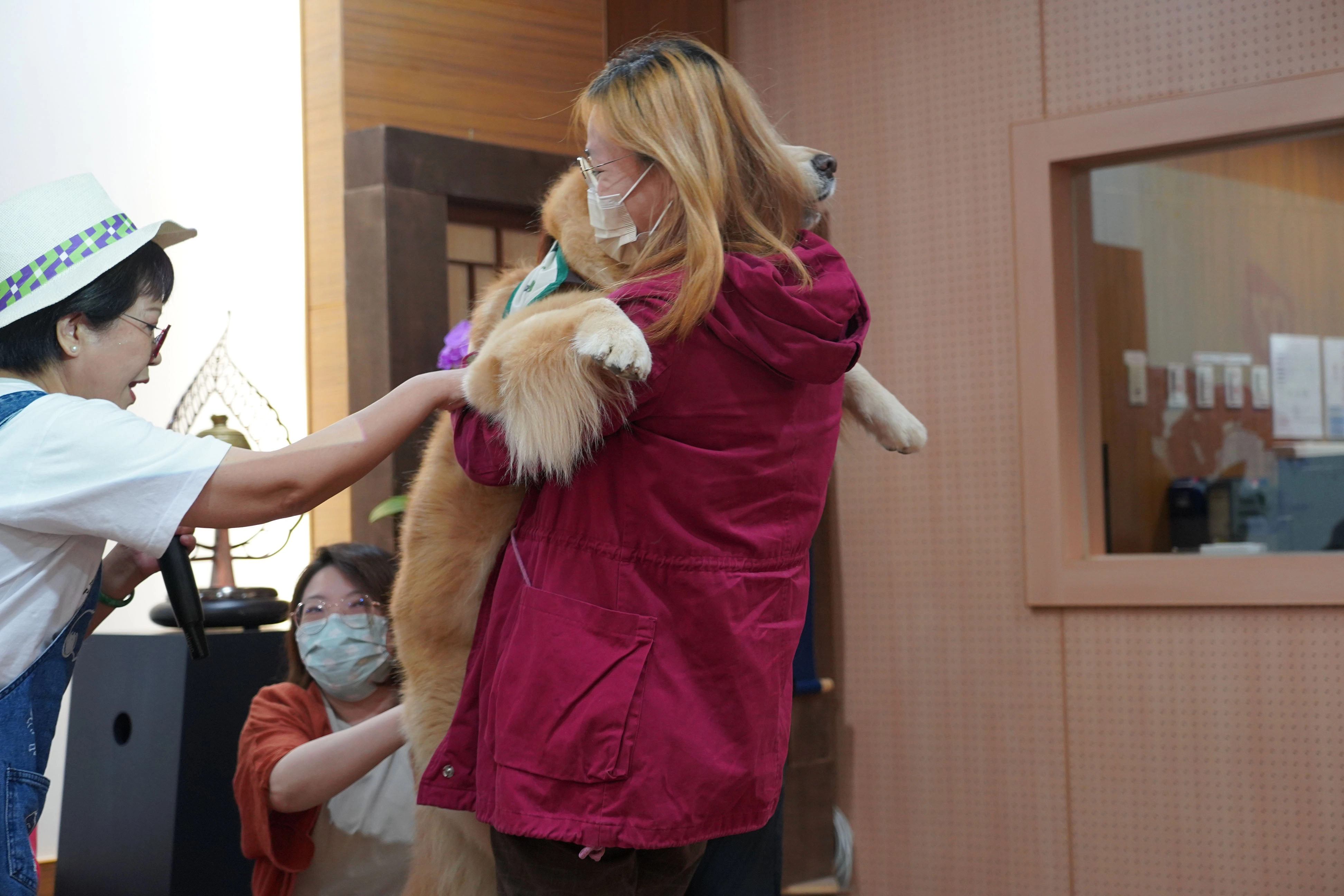 學員郭小姐（右）在講師陳美麗（左）的引導下，與治療犬貝貝擁抱，體驗最溫暖的療育力。