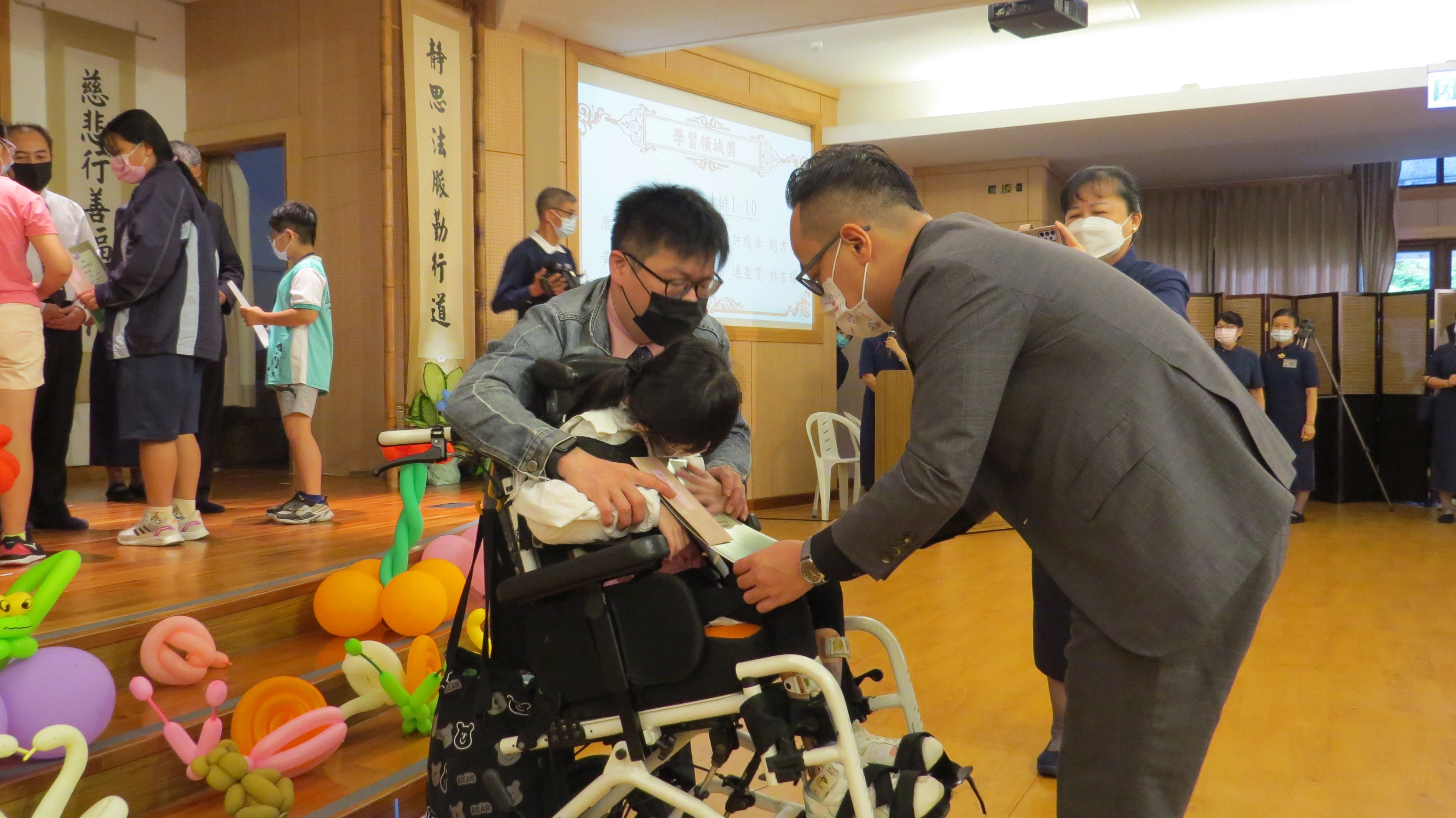 基隆市議會童子瑋議長為坐在輪椅上的趙同學頒獎。