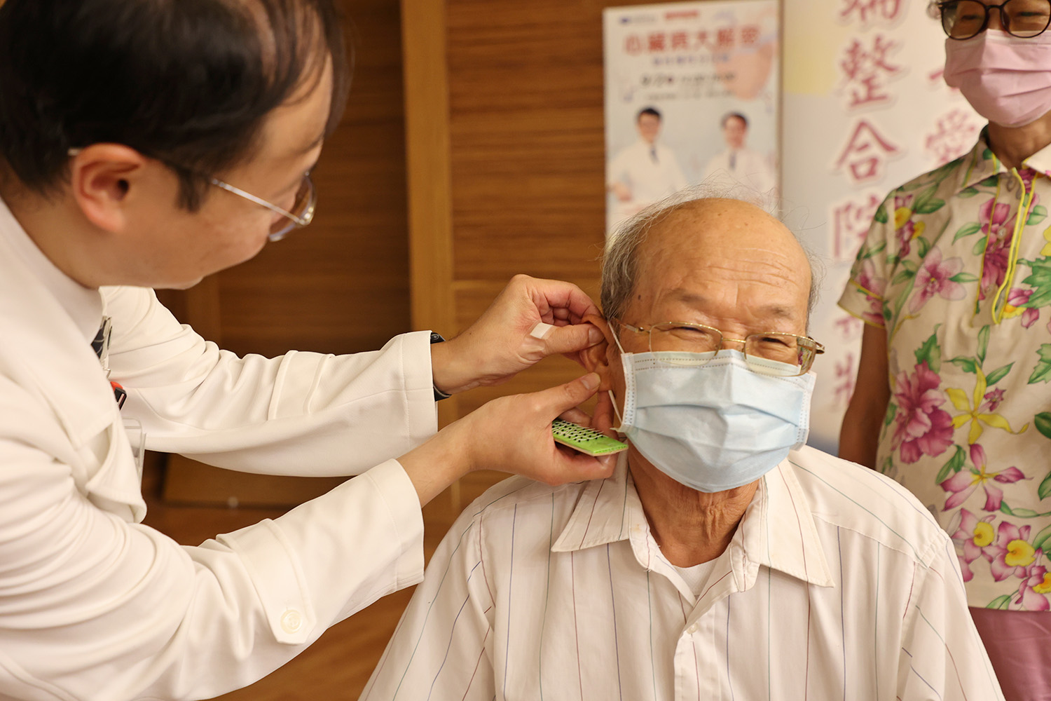 林經偉主任為民眾貼上耳豆貼,祝福大家都能護心養心,健康安心。