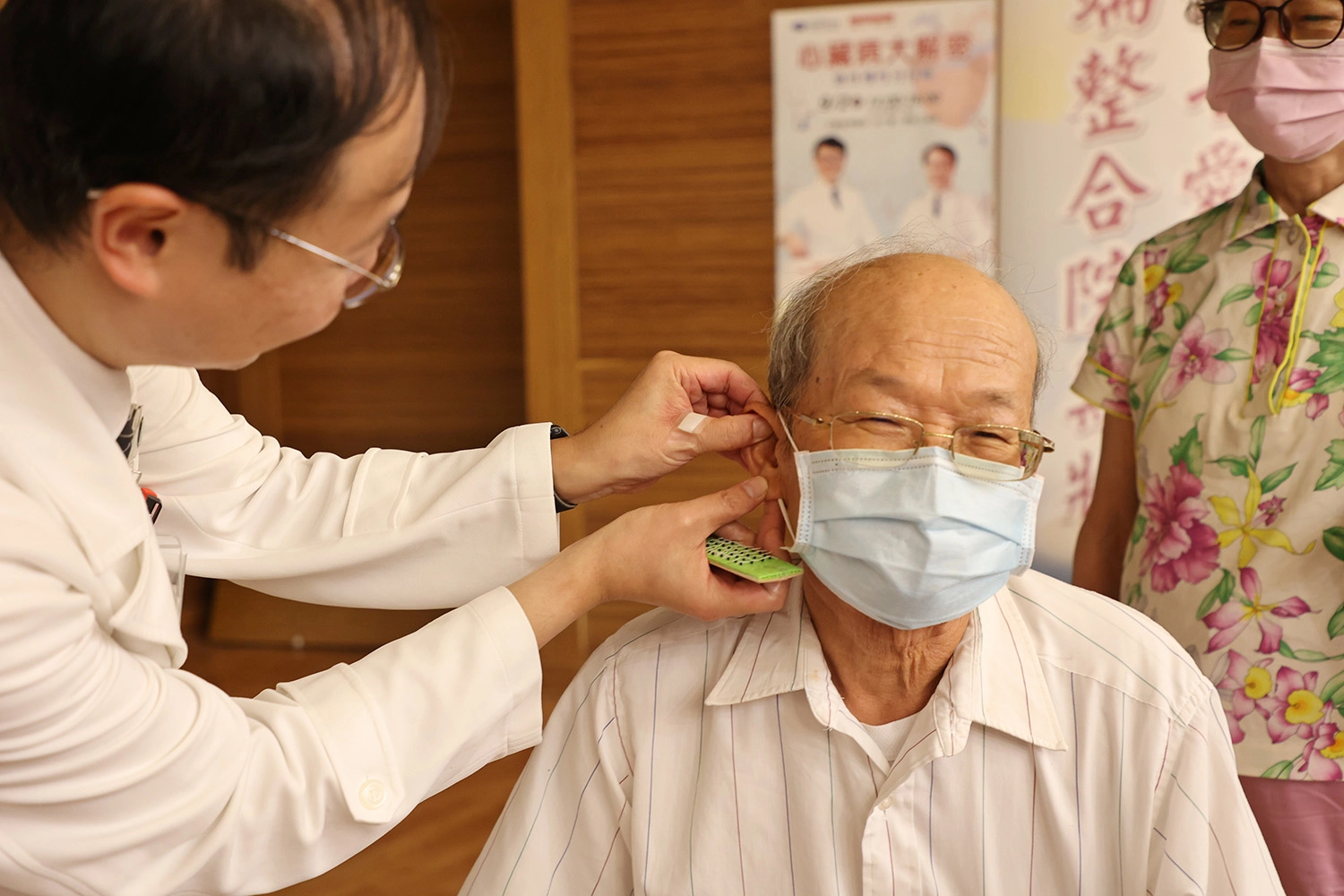 林經偉主任為民眾貼上耳豆貼，祝福大家都能護心養心，健康安心。
