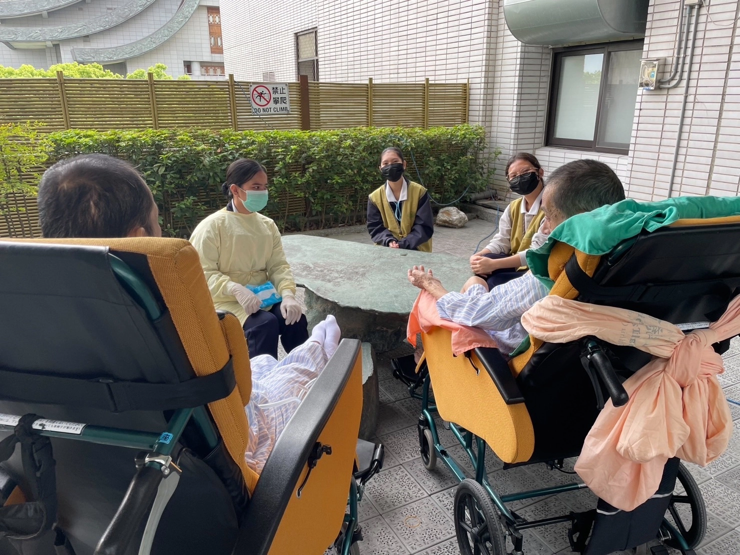 學生陪伴病人在戶外聊天散心。