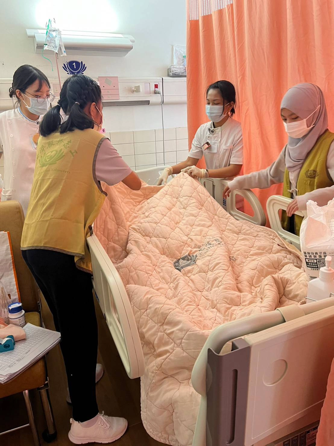 學生向護理師學習如何協助病人換床鋪。