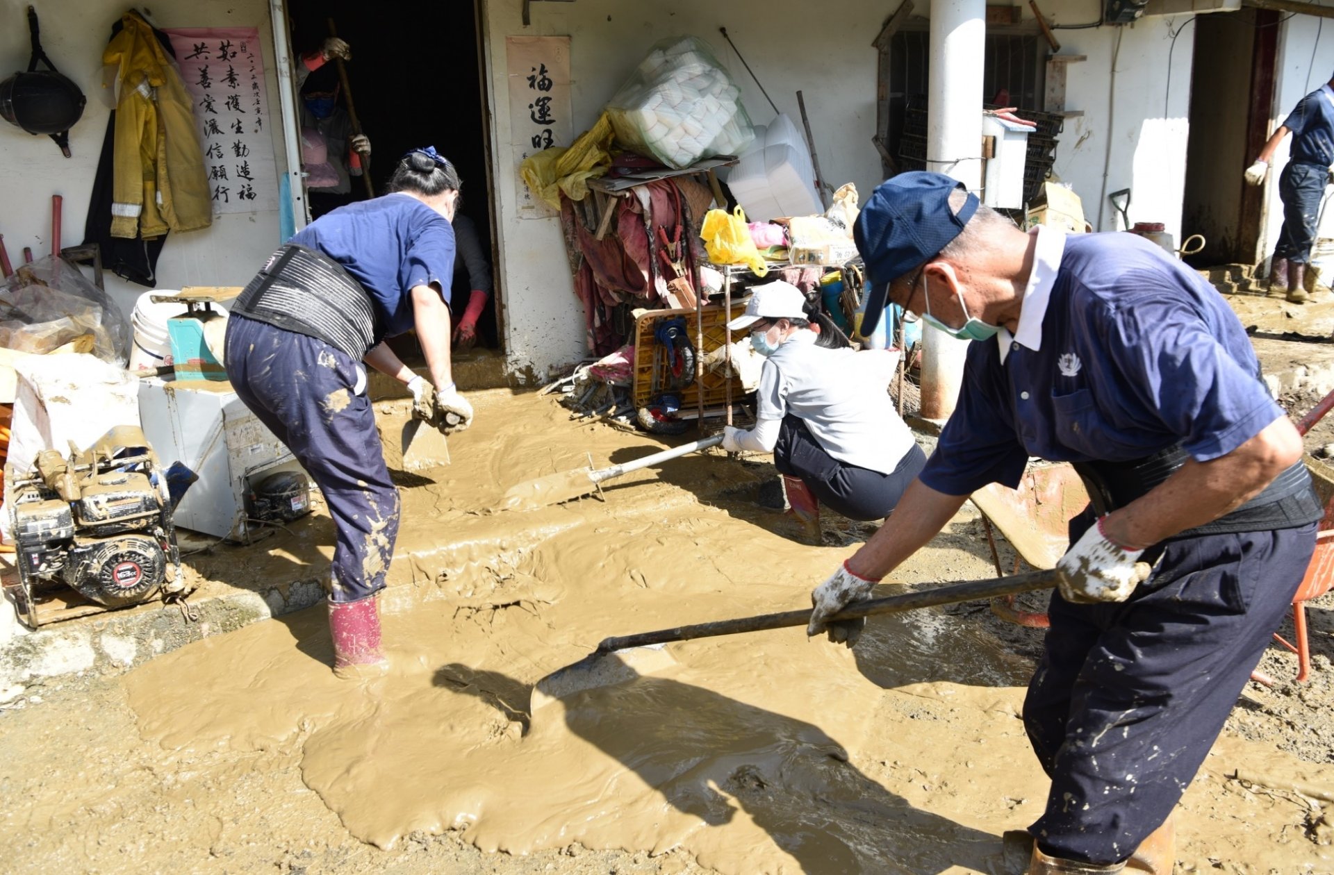 慈濟志工搭配壽豐鄉公所的機具作業，將屋內土石運出。