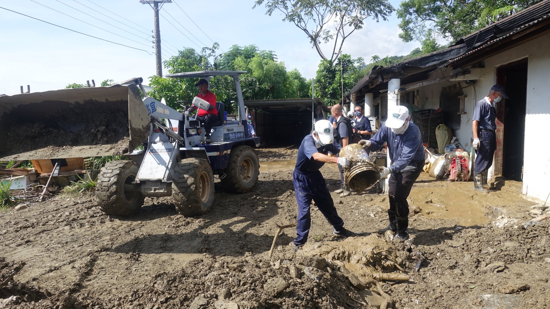 慈濟志工搭配壽豐鄉公所的機具作業，將屋內土石運出。
