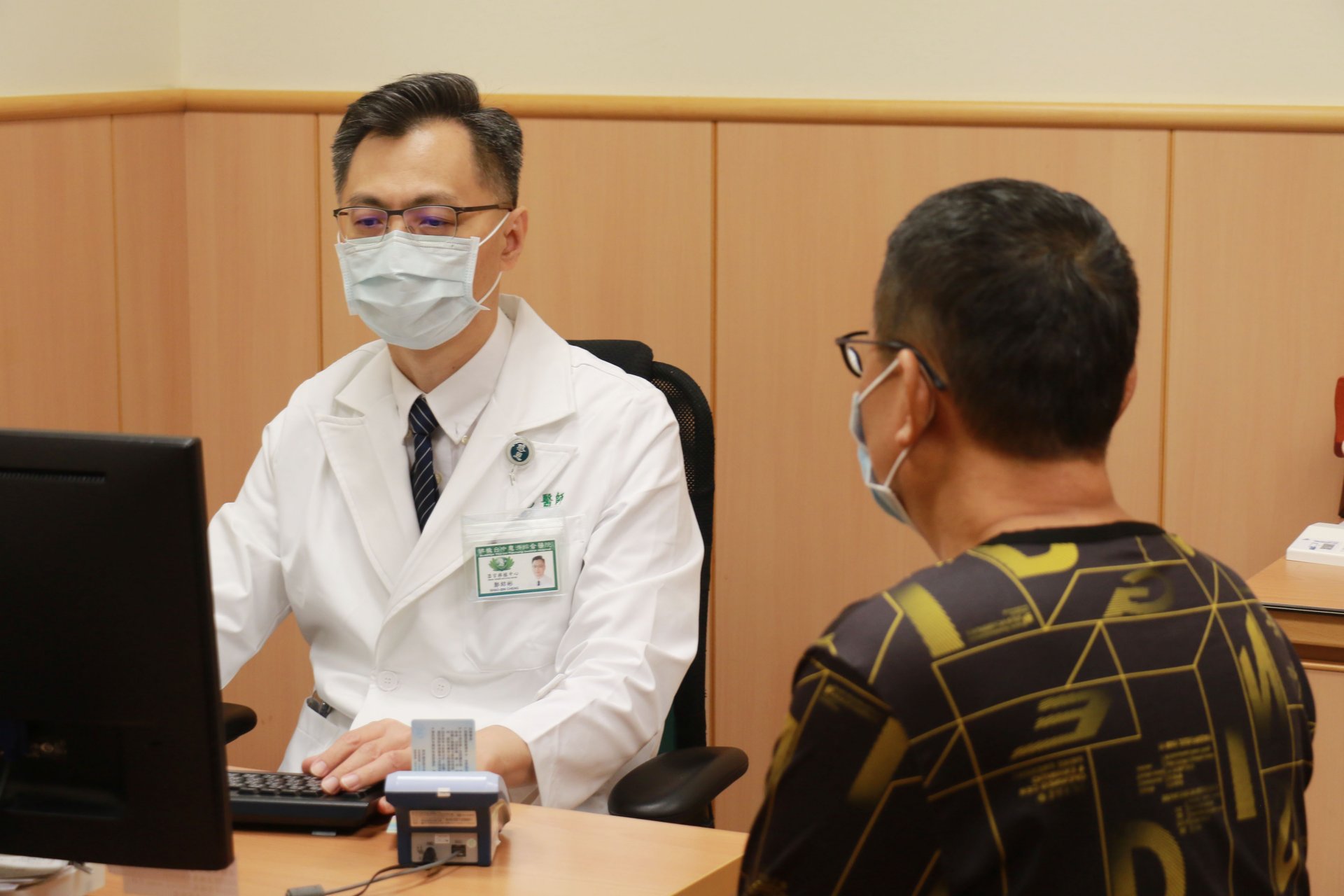 獲大愛肝臟移植的郭先生（右）定期回診讓鄭紹彬主任（左）調整藥物，並努力復健讓身體功能恢復。