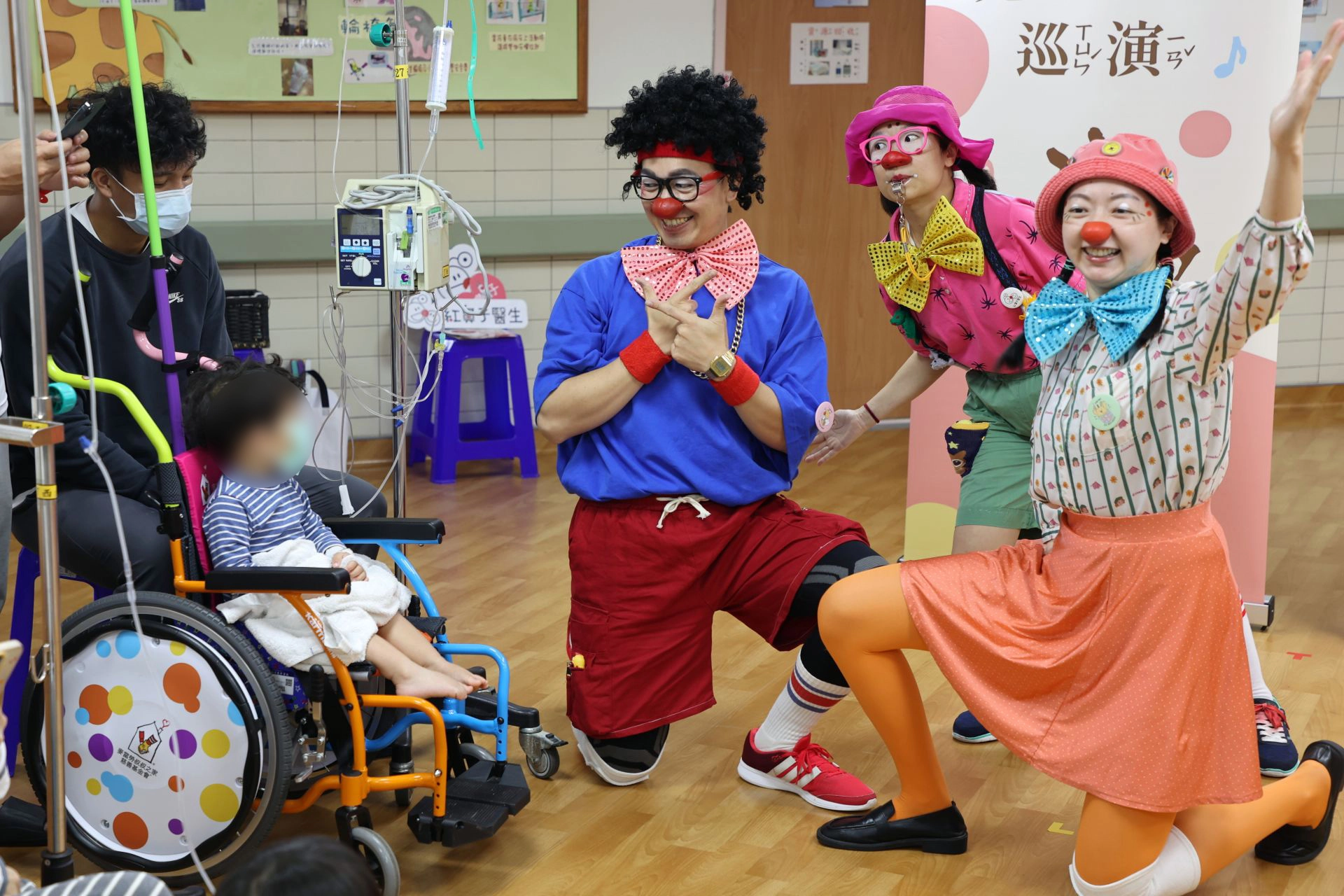 三位小丑醫生與病童開心互動。