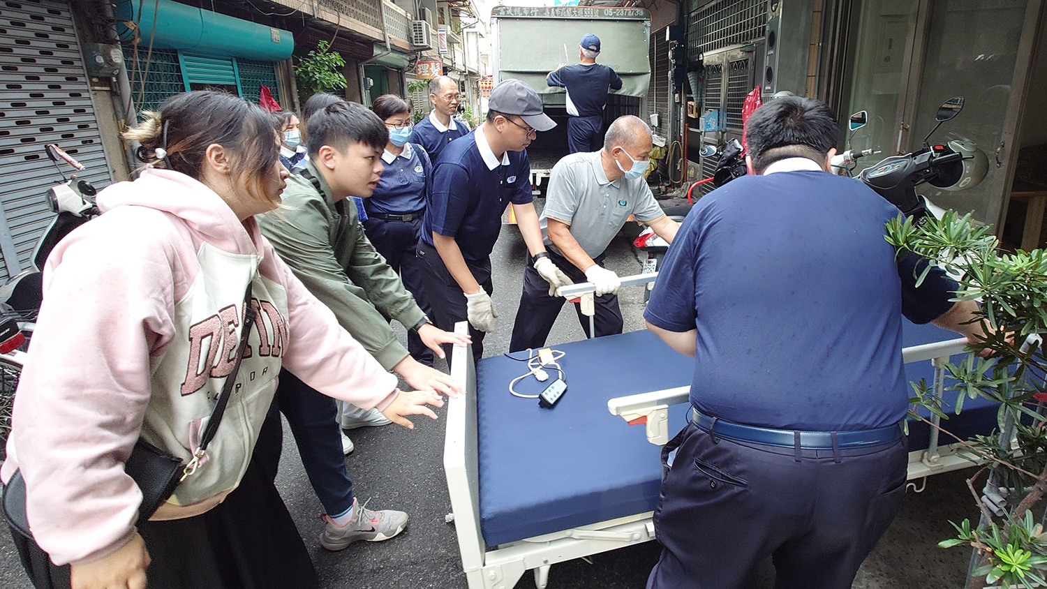 (上)熱血年輕人，利用假日和志工運送電動醫療床到案家，給予案家溫暖的關懷。