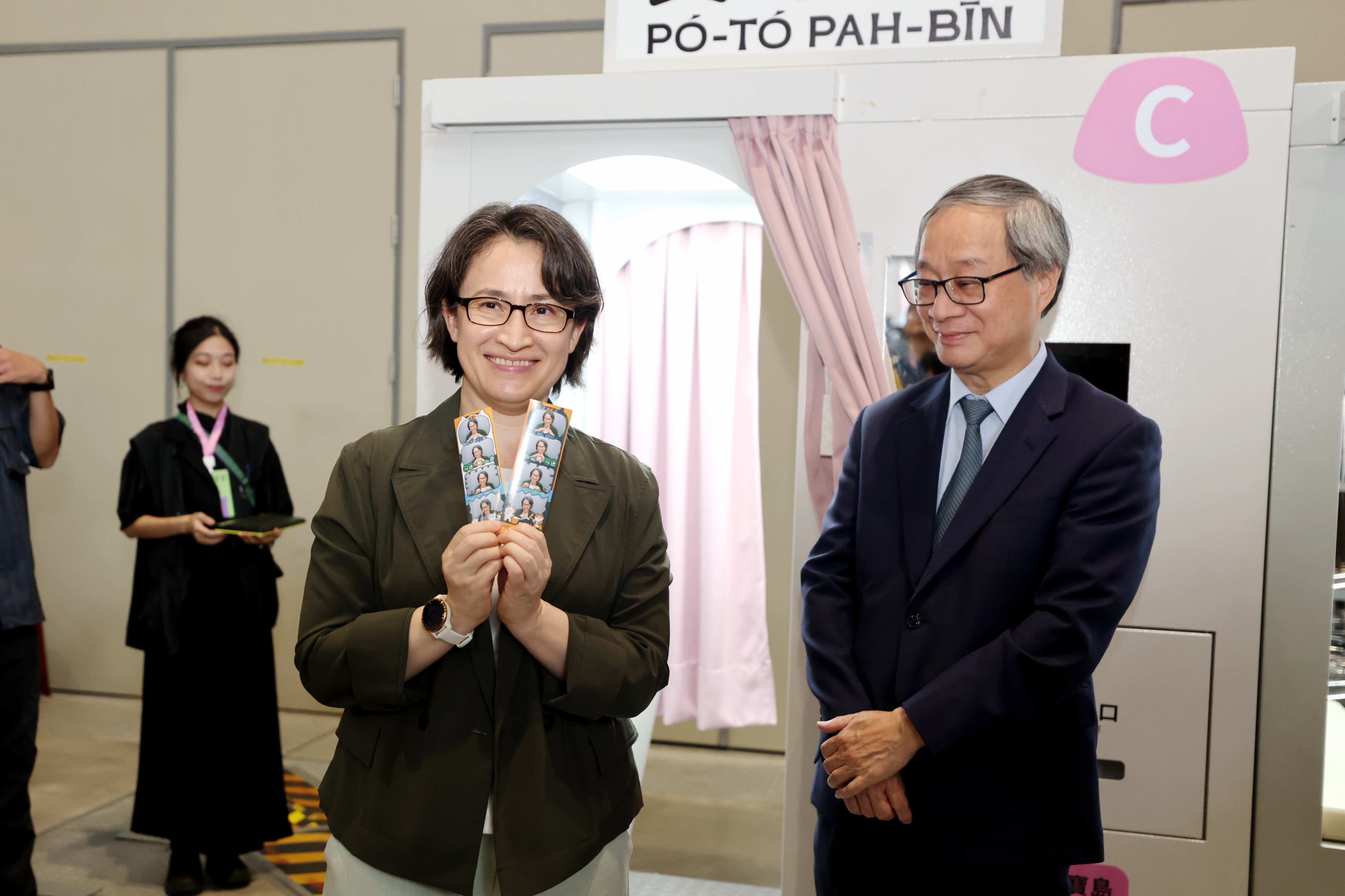 副總統蕭美琴（左）體驗由創作者「美可女子」以花蓮為元素，貓咪搗麻糬及豐年祭的拍貼機。