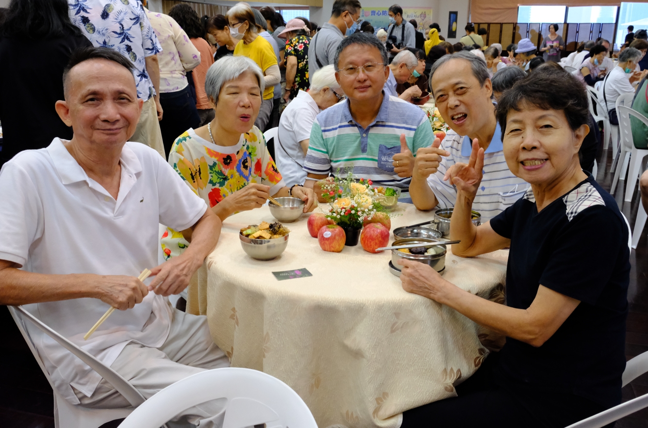 第一次接觸素食的會眾梁鴻明(左一)，對今天的素食讚不絕口，他說：「沒想到素食這麼好吃」。