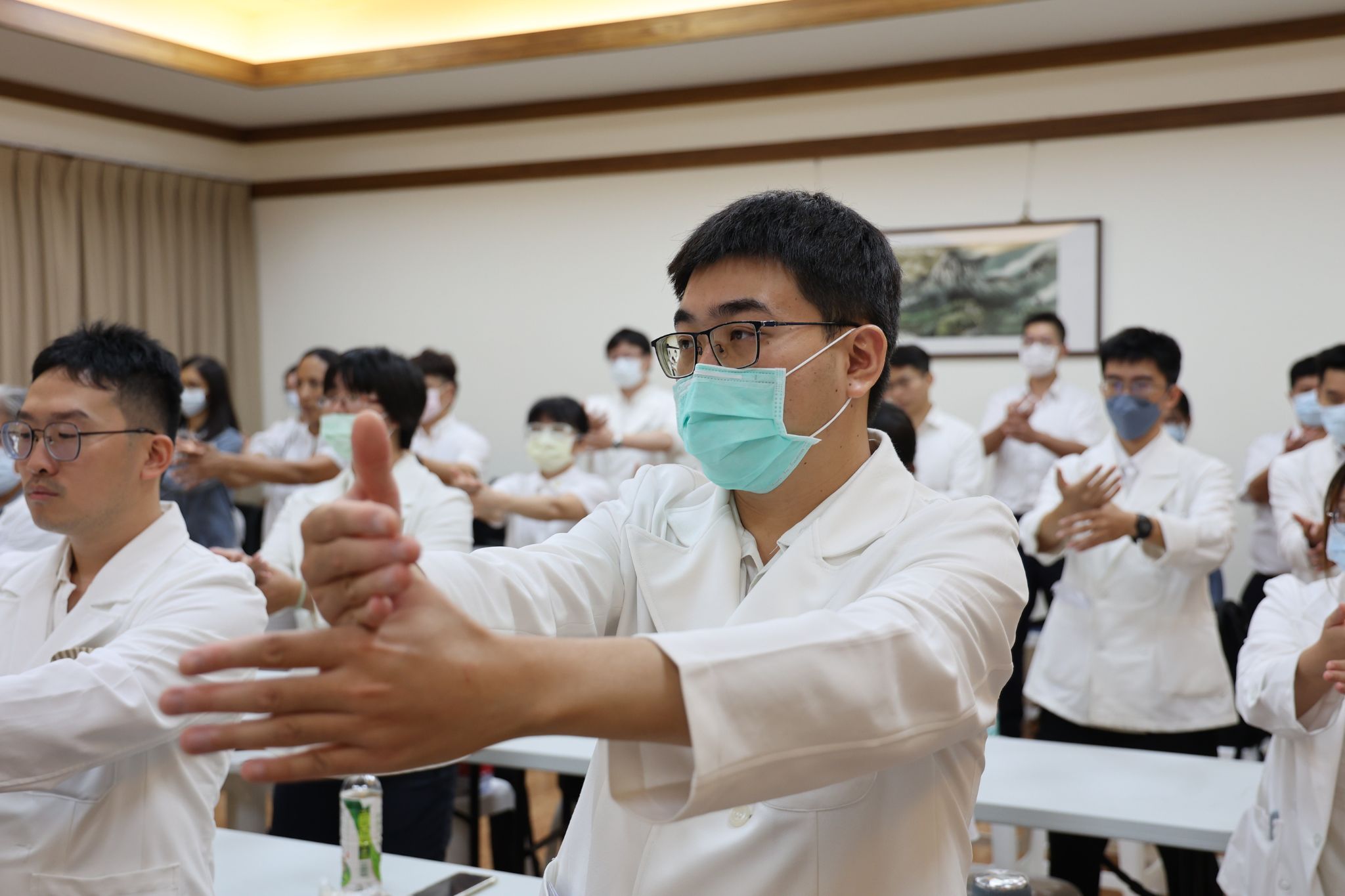 何進修大師與同道何宗殷師兄、花蓮縣外內丹功研究學會代表陳師姊，現場帶動學員進行練習，外丹功十二架中的「蹲身甩手百壽功」。