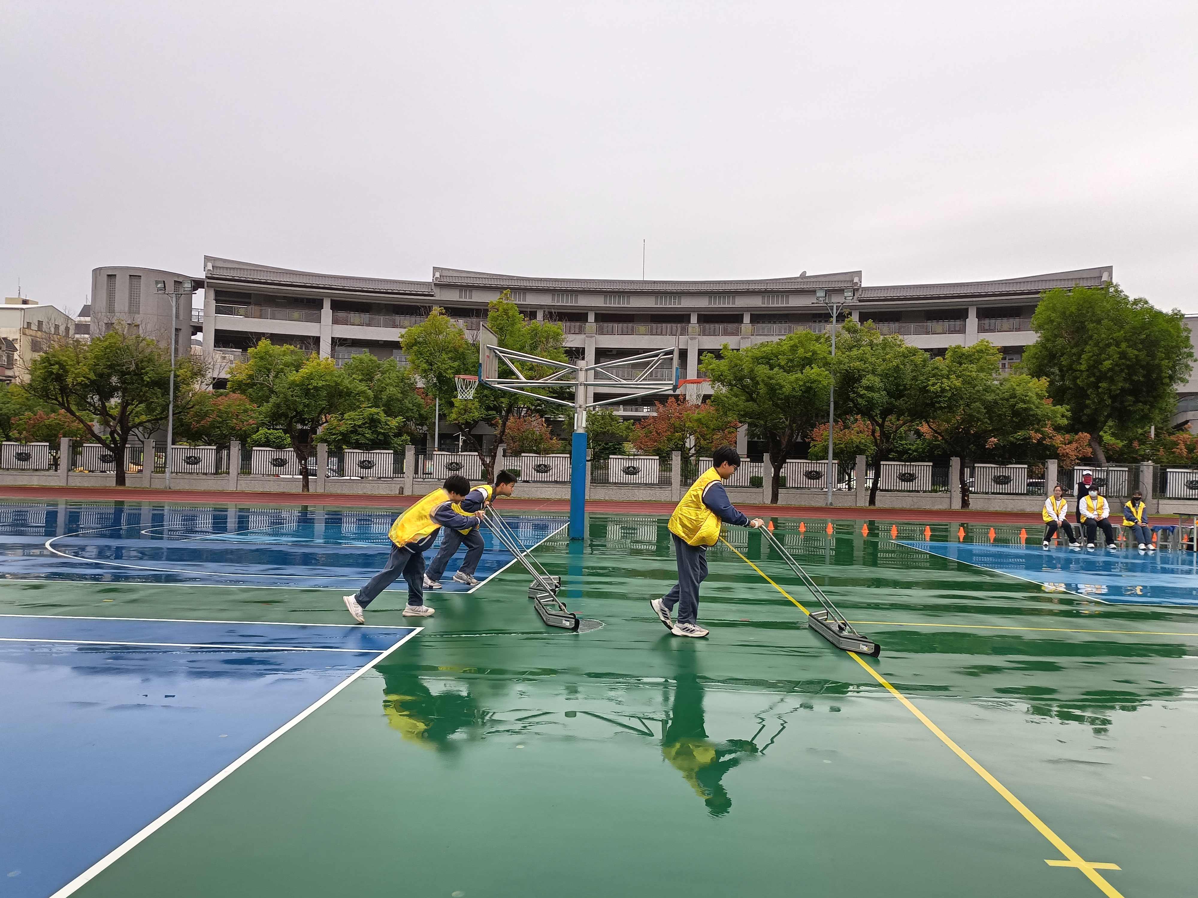 開賽前，志工同學努力清掃下雨的積水。