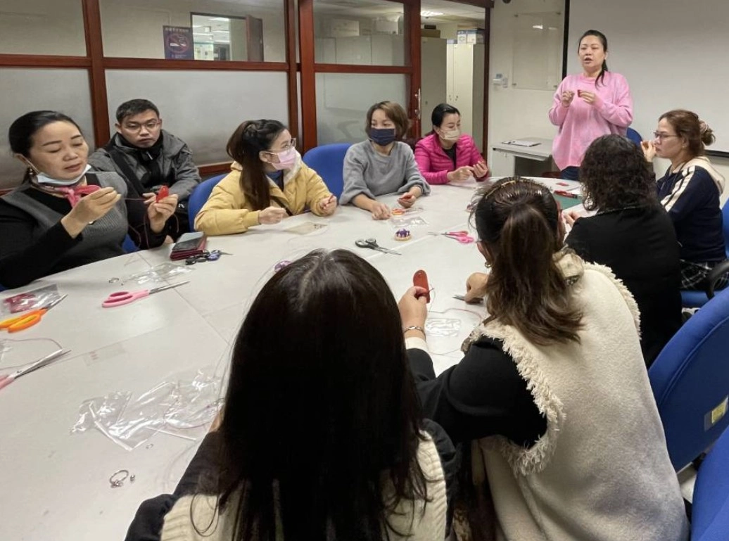 新住民家庭服務中心講師洪珮雲(站立者)為上課學員講解製作龍年紅布包及剪春字做法。