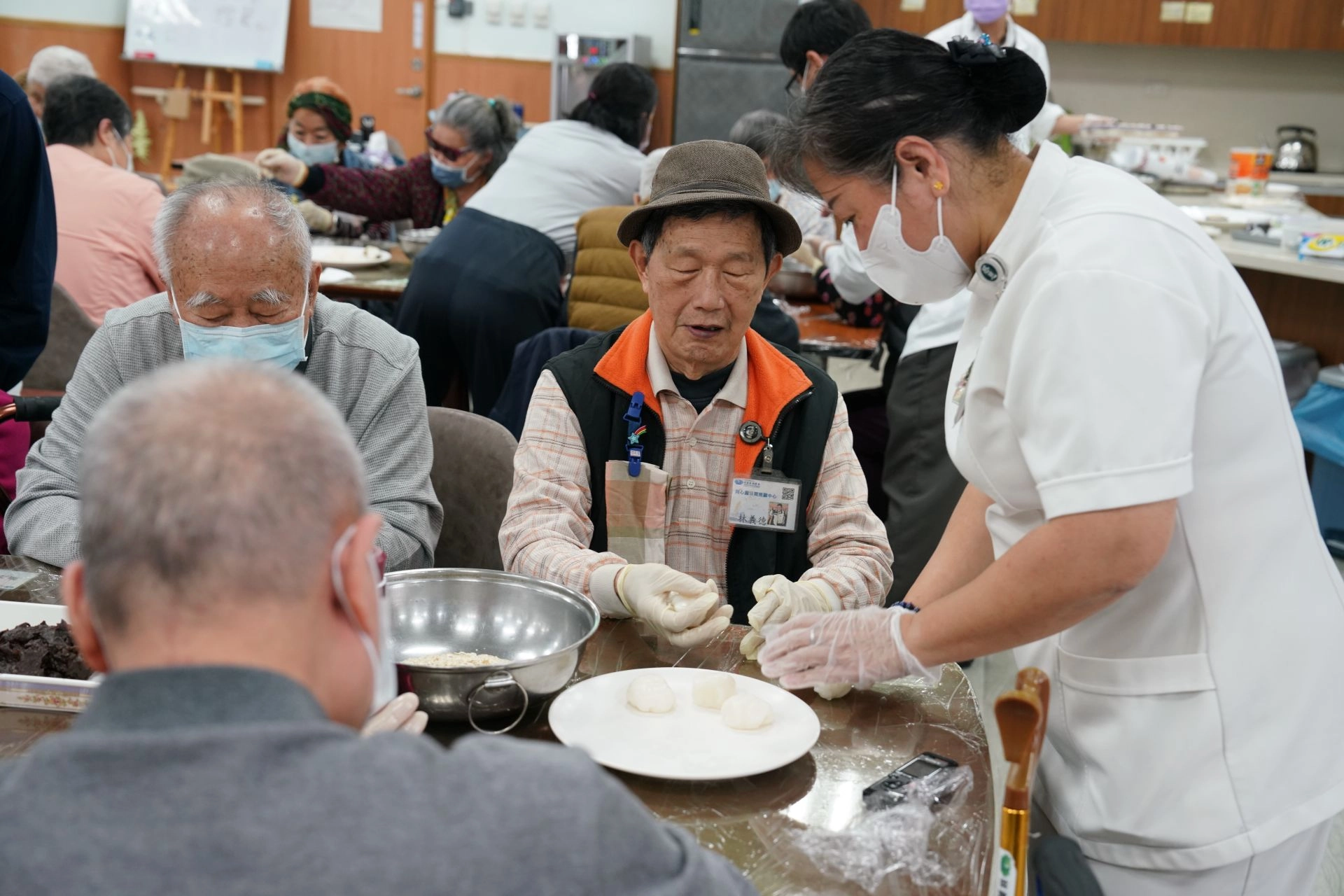 花蓮慈院日間照顧整合中心主任張幸齡(右一)，細心指導長輩做元宵。