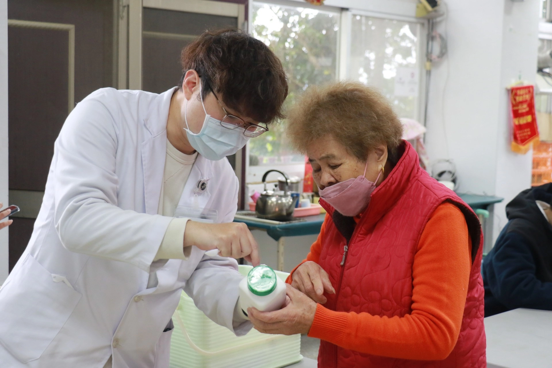 中醫部洪振峰醫師（左）為鄉親詳細解說用藥方式。