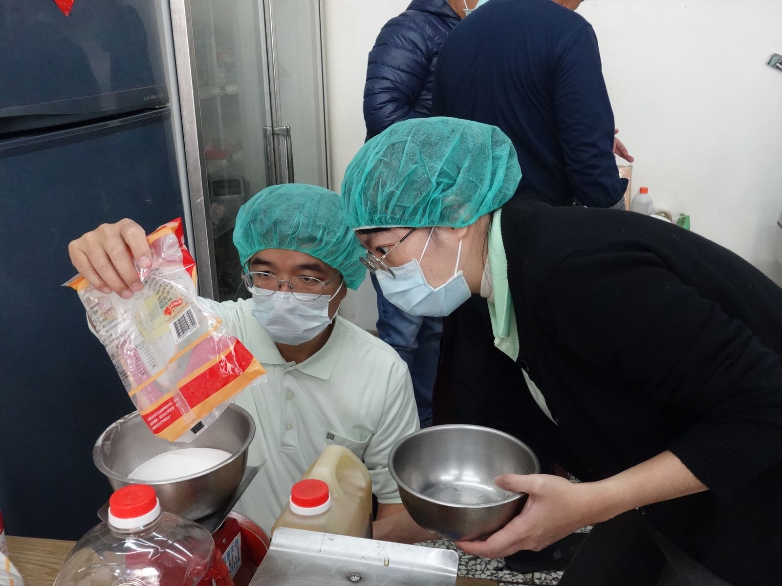 斗六慈濟醫院院長室高級專員陳鈞博（左）與同仁專心幫材料秤重
