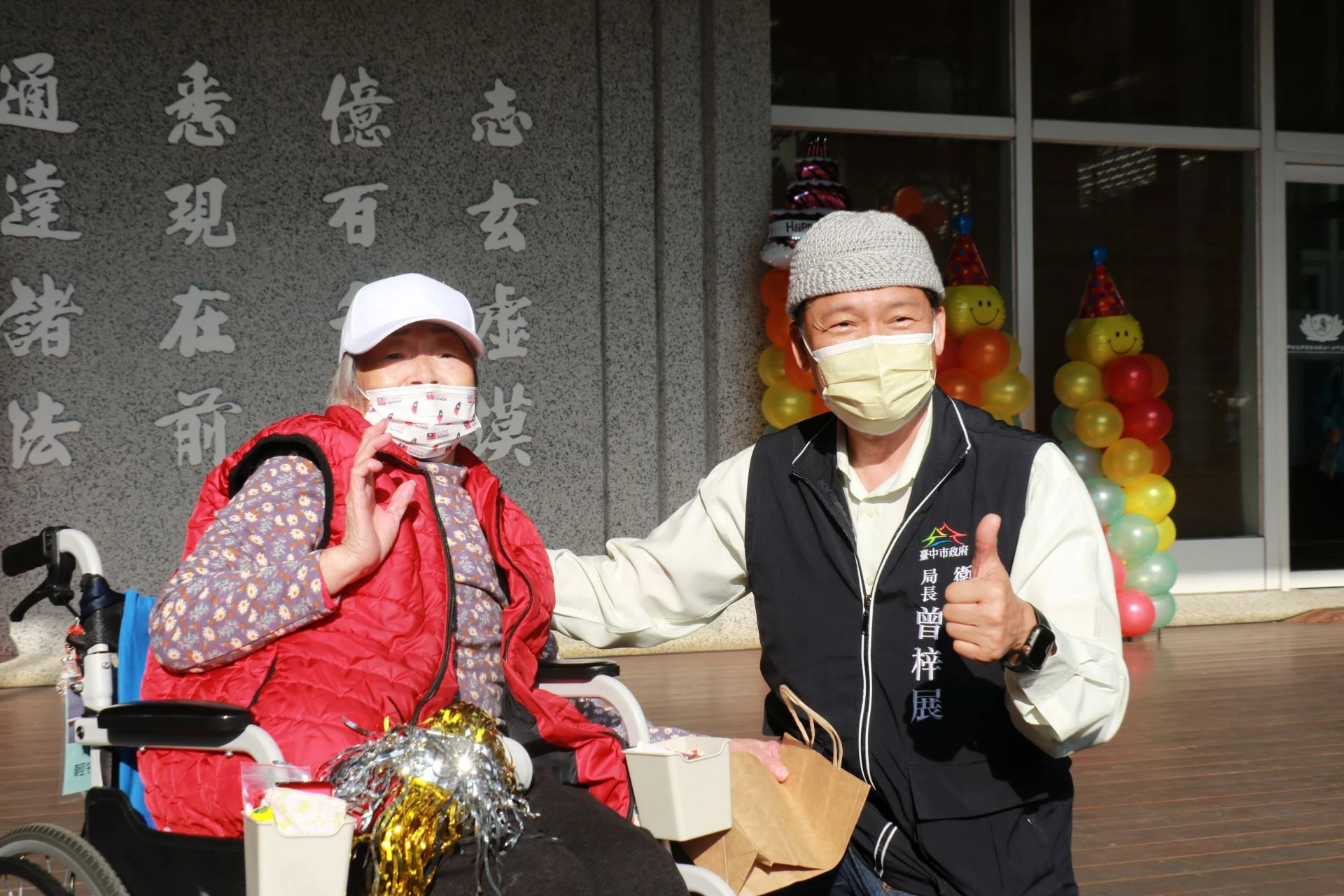 百歲人瑞褚奶奶（左）以親手織縫的毛帽贈臺中市政府衛生局長曾梓展（右）表達感恩。