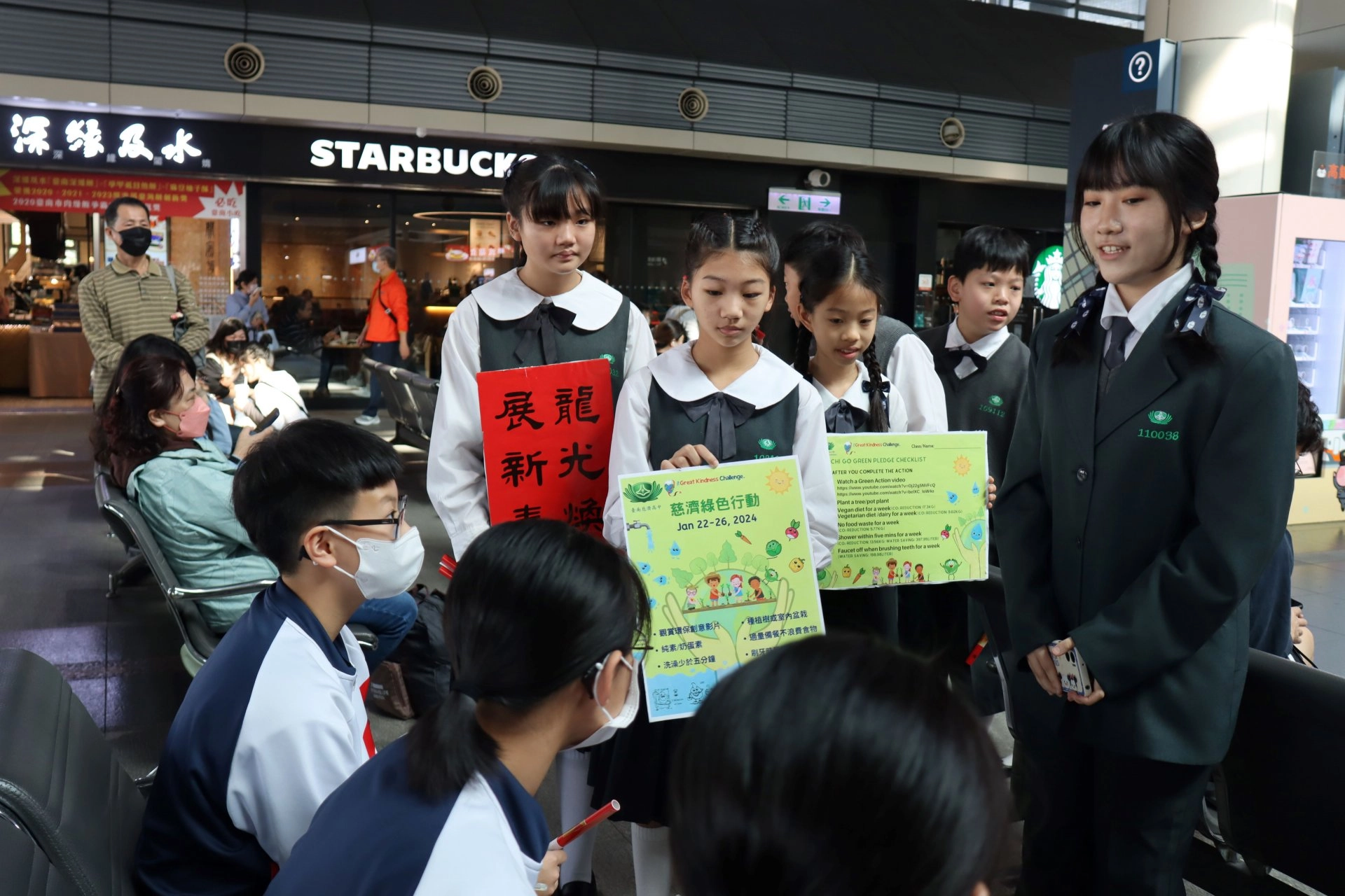 中學部的學姐帶領國小部的學弟妹一起向旅客宣導綠色行動。