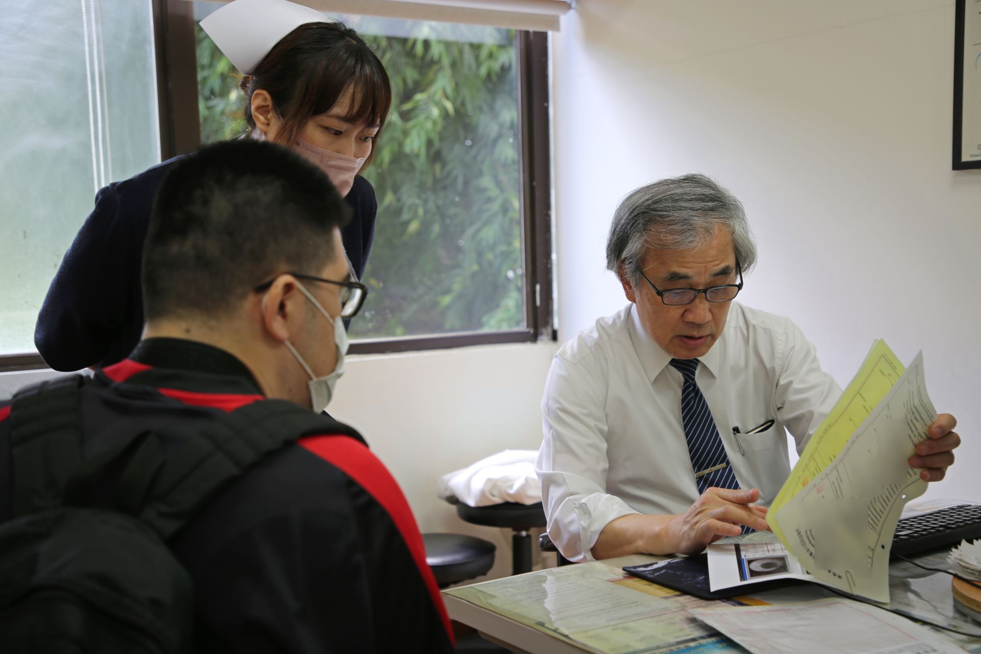 郭漢崇主任和個管師吳之云向初診的房明璋確認平時排尿情況及感染頻率，並為他安排當日的檢查。