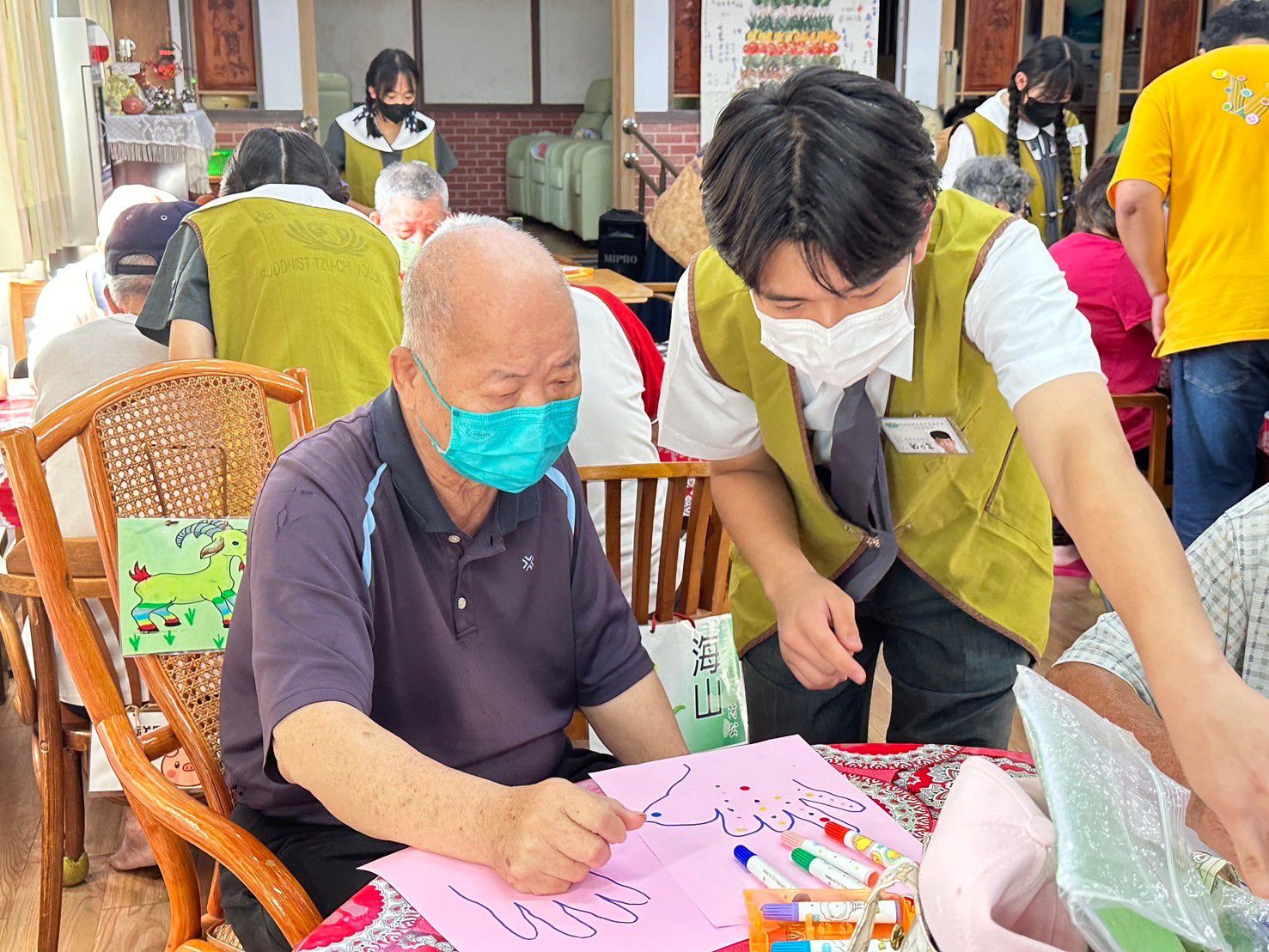 高中戴川富同學(圖右)與中學生們幫忙爺爺奶奶們完成手腦並用的遊戲。