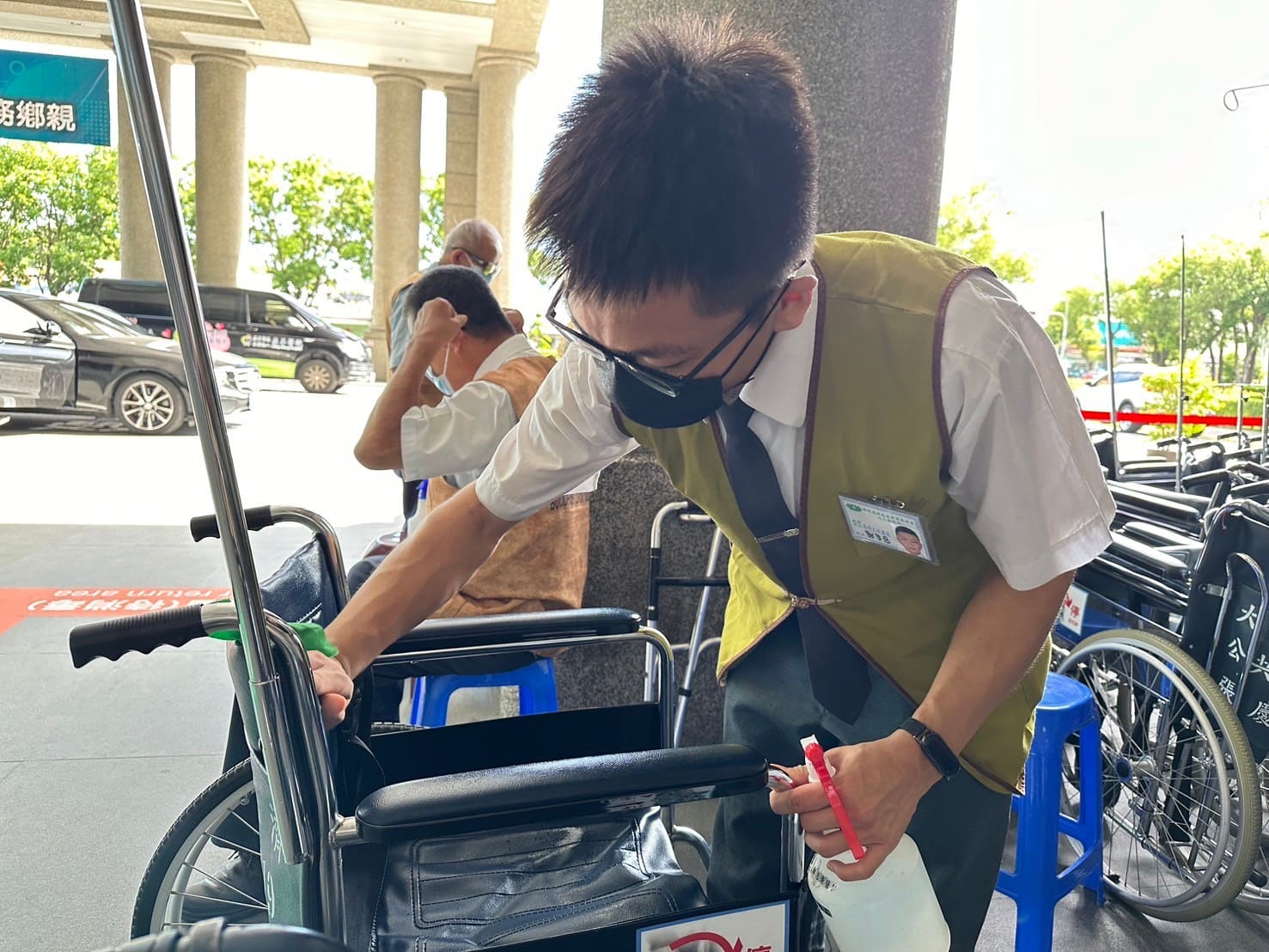 頂著大門外高溫，同學依舊細心消毒輪椅。