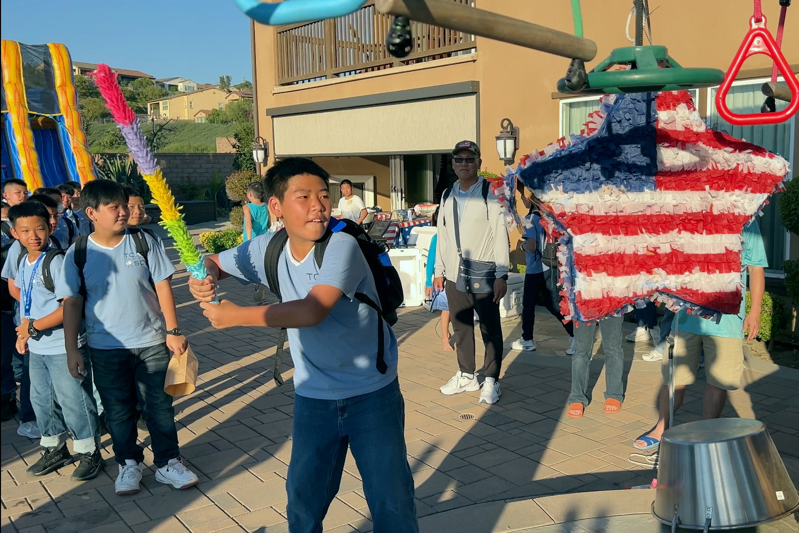 國慶日，孩子揮擊以美國國旗為底圖設計的皮納塔(Piñata)，體驗異國文化。