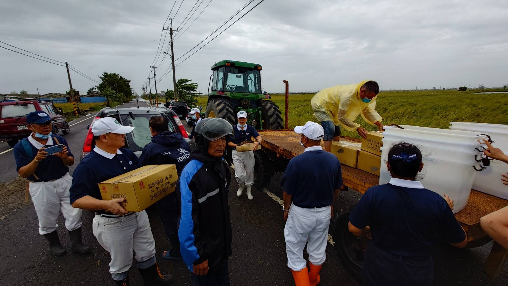 熱心的村民動用大型鐵牛耕耘機，準備載運志工到災區發放便當。(攝影：施哲富)