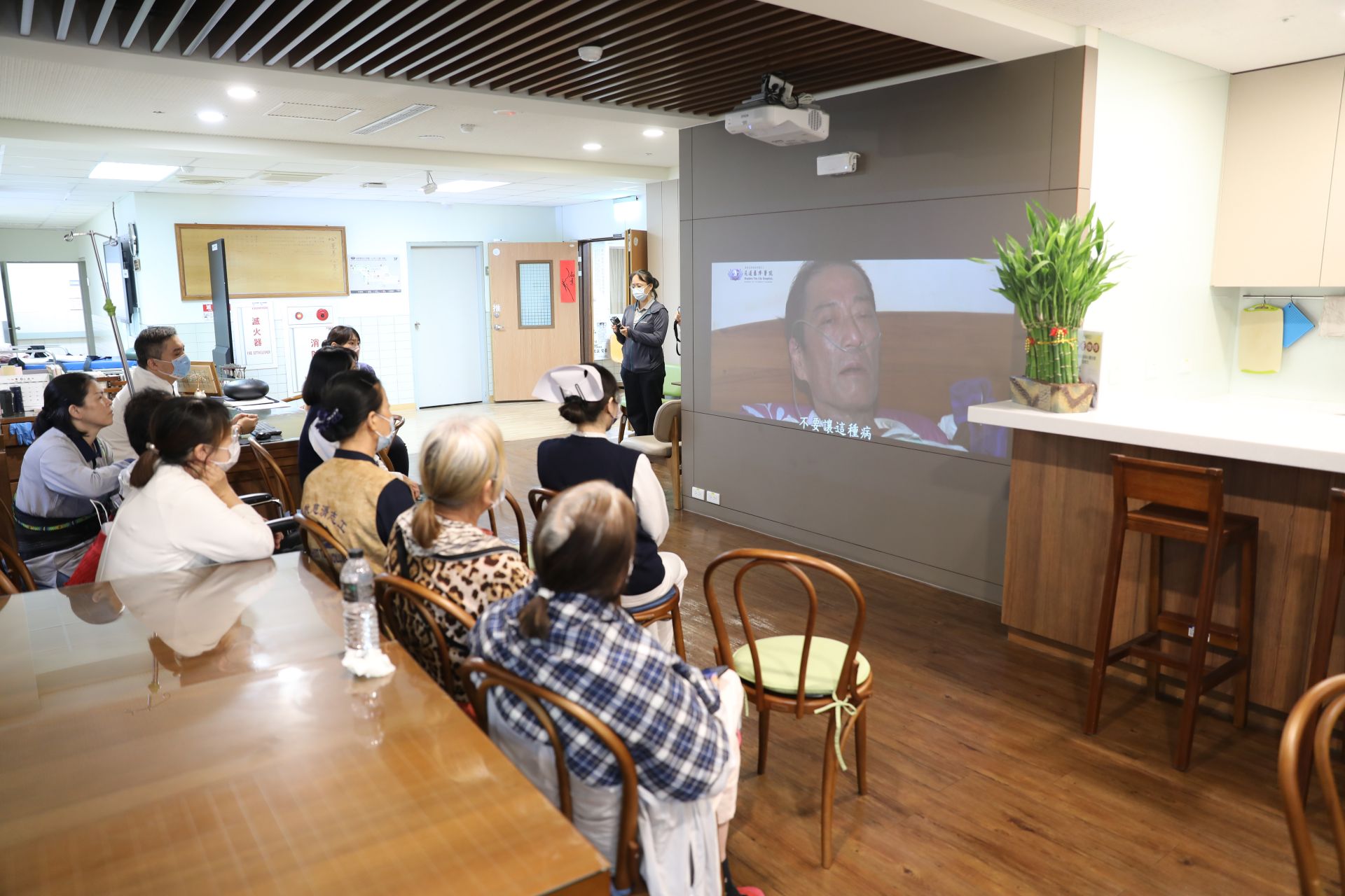 06/26下午，花蓮慈院團隊在心蓮病房交誼廳舉辦首映會，邀請團隊與志工一同見證，心蓮病房護理師鄧淯勻現場為林永金送上祝福的花束。