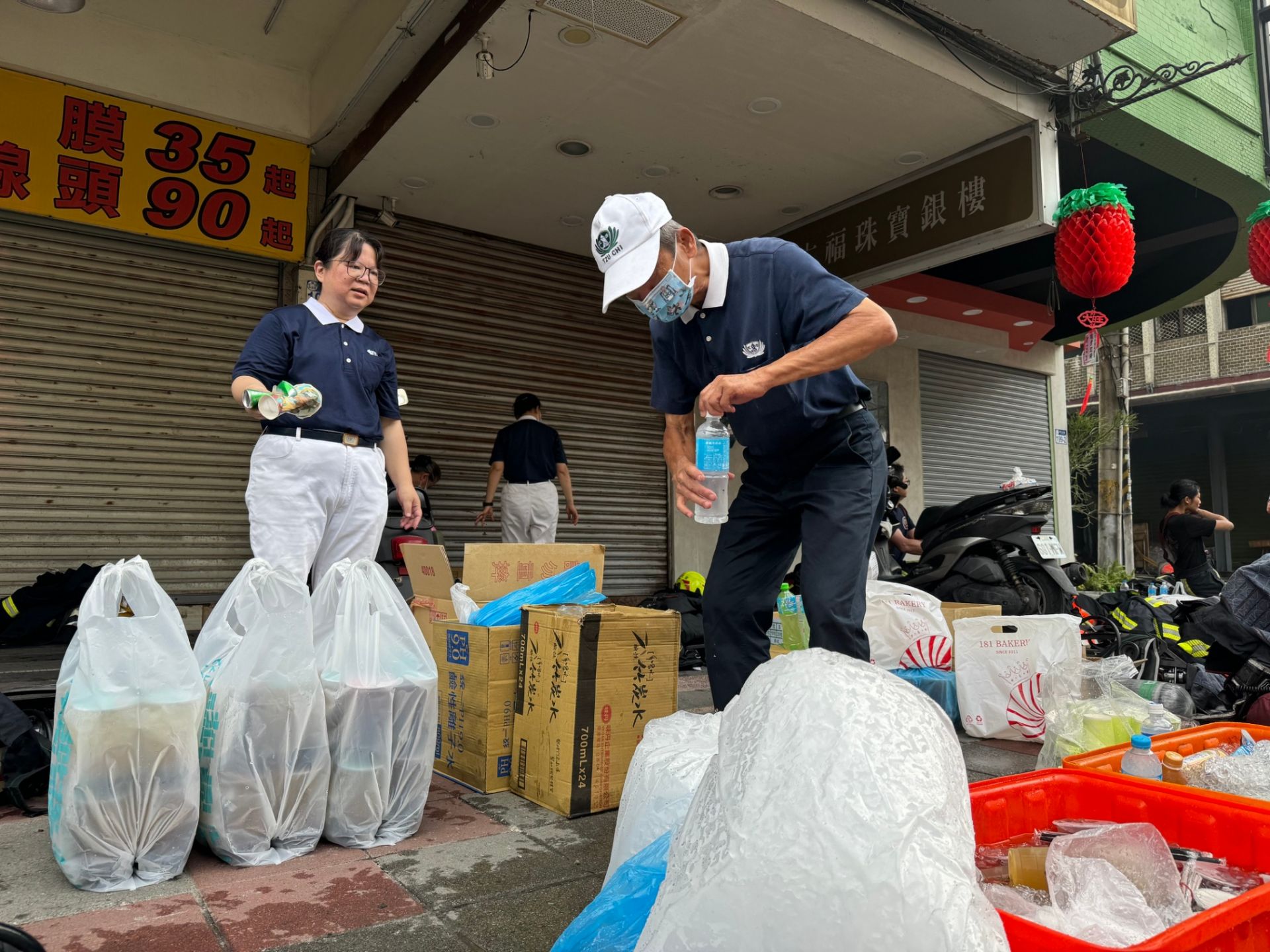 慈濟志工準備水、食物讓警消使用，並主動整理周圍環境，減輕消防人員整理工作。