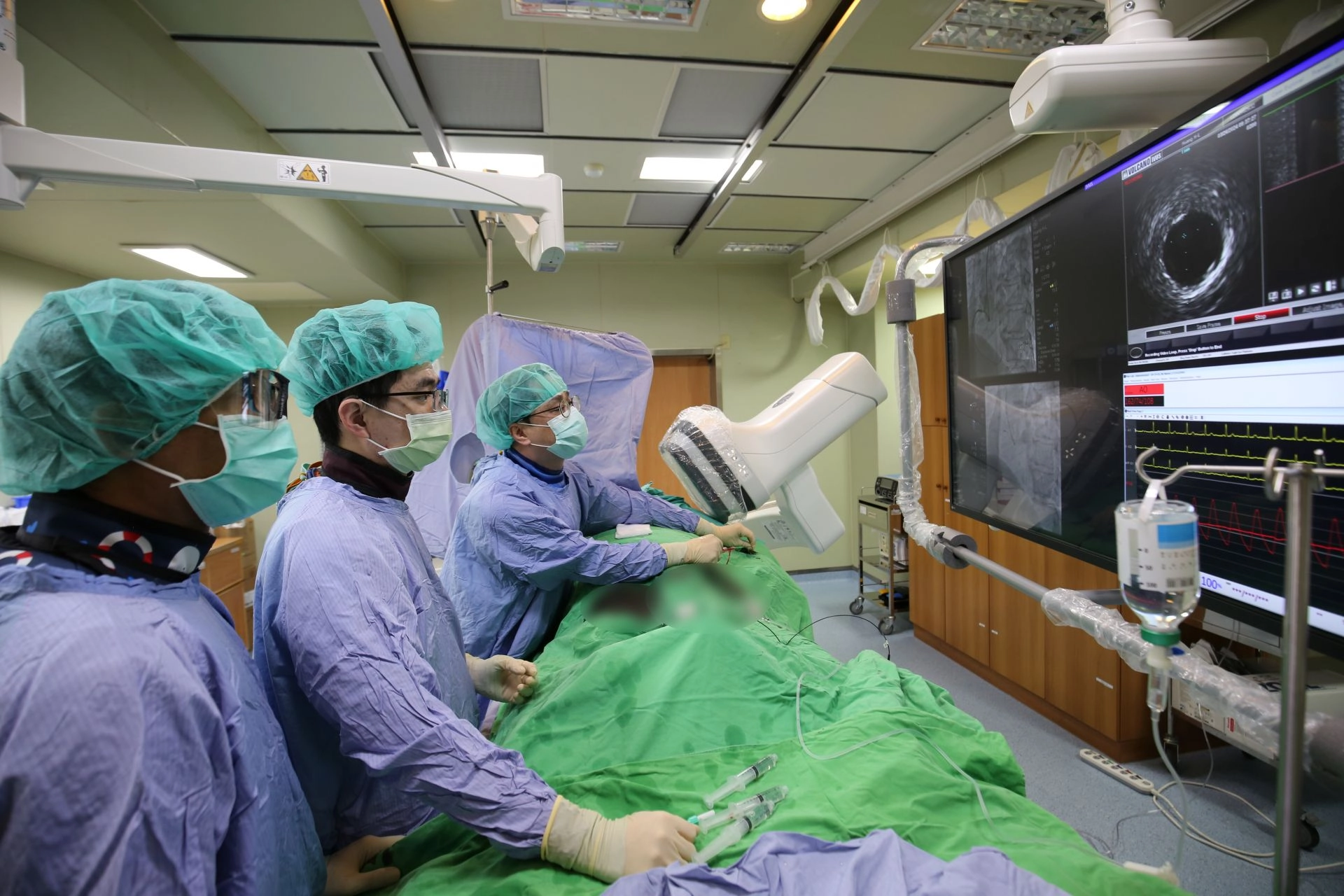 內科部副主任、心臟內科醫師陳郁志(右)使用新一代「心臟血管攝影X光機」執行術式。