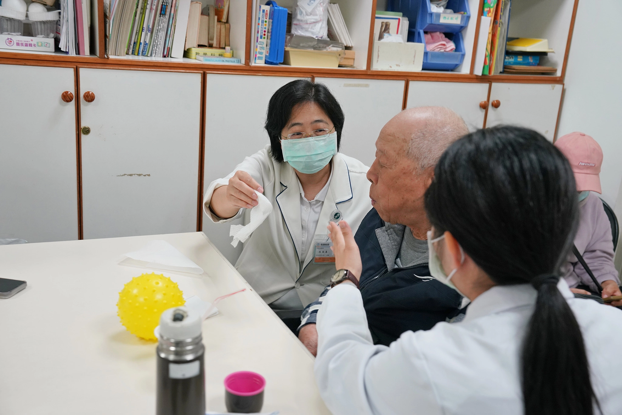 陳佳惠語言治療師(左一)幫王先生進行舌頭動作訓練。