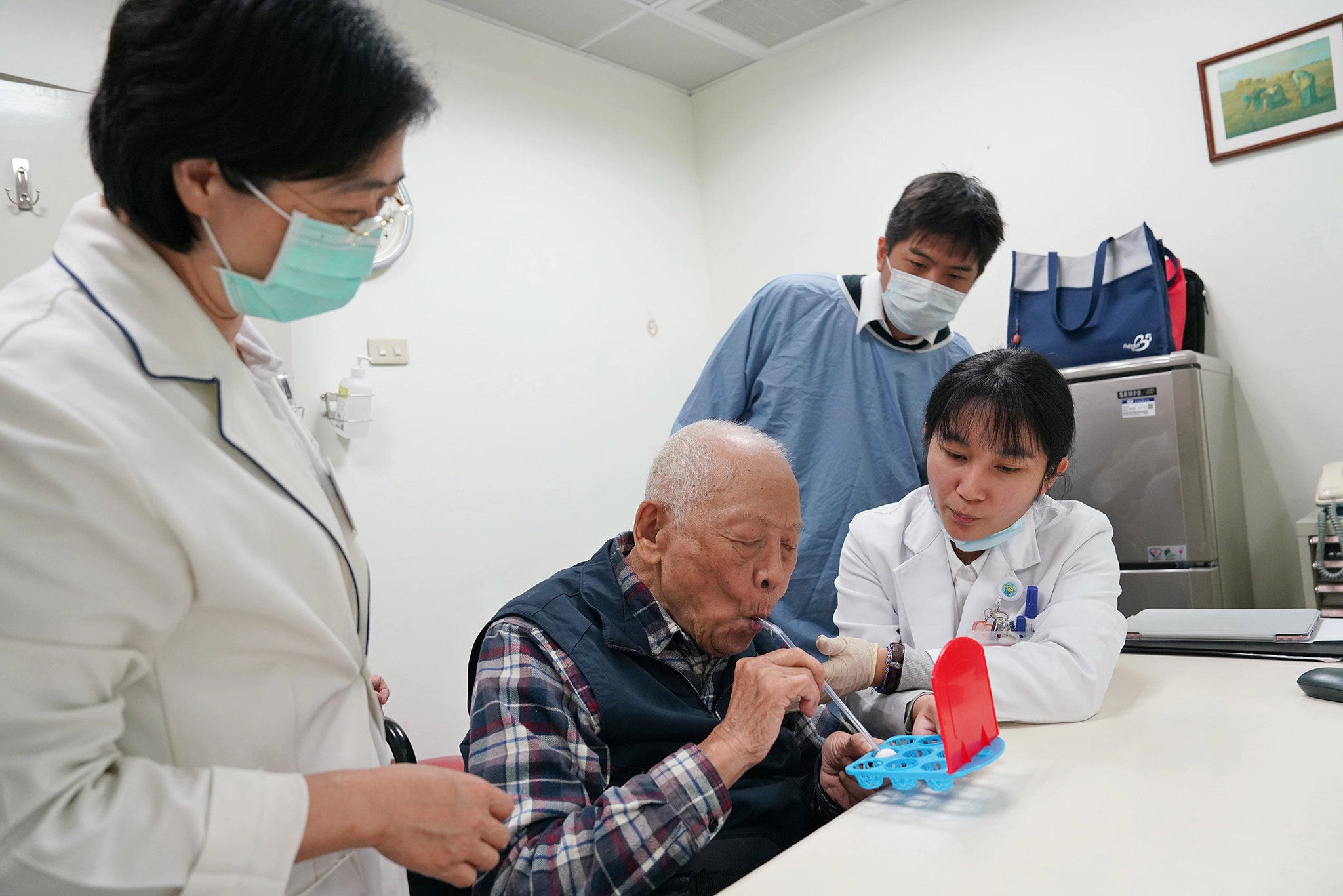 葉映廷主任(右二)與陳佳惠語言治療師(左一)觀察王先生吞嚥練習情形。