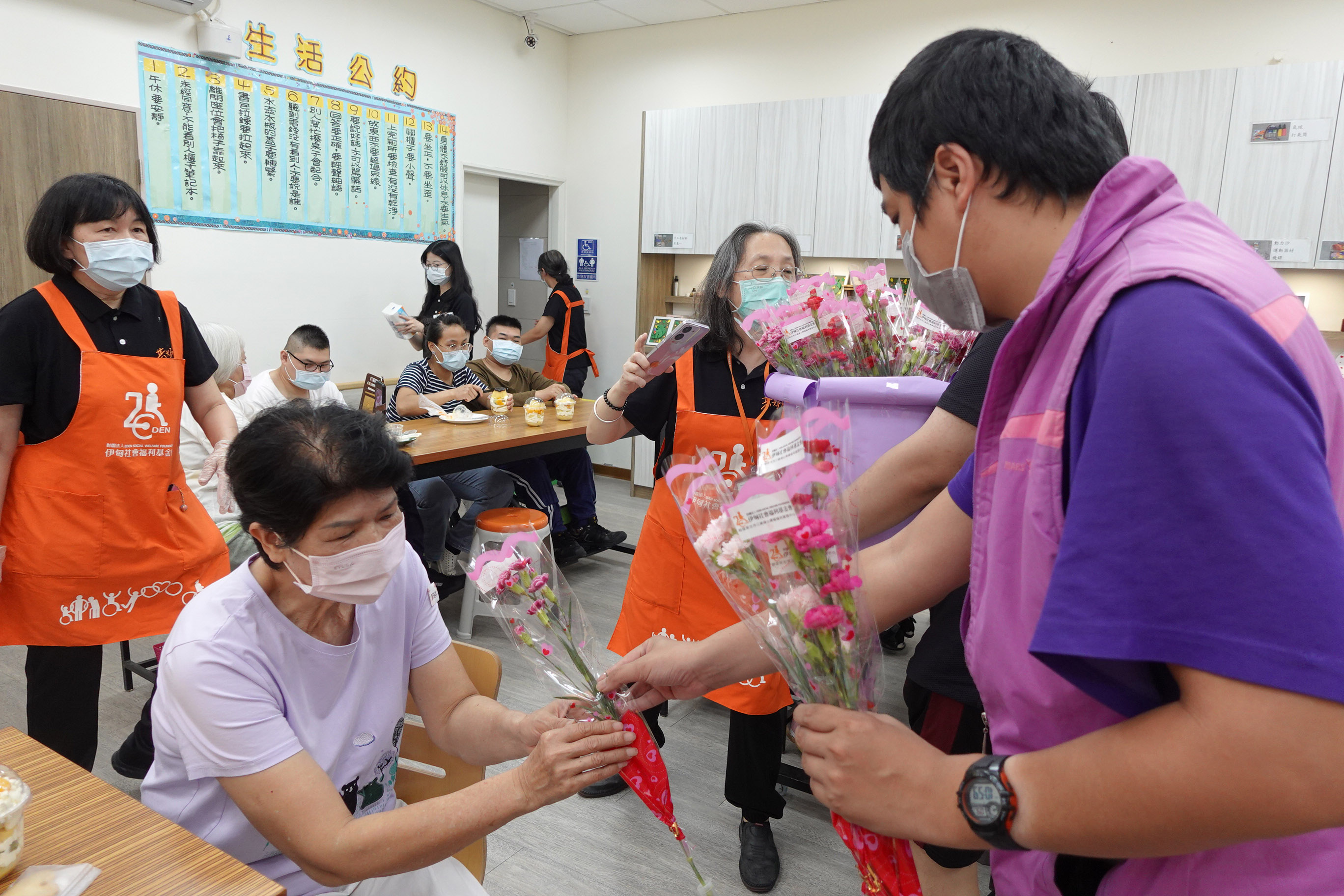 伊甸三峽國光日照中心的阿翔，為據點長輩們獻上康乃馨，提前祝他們母親節快樂