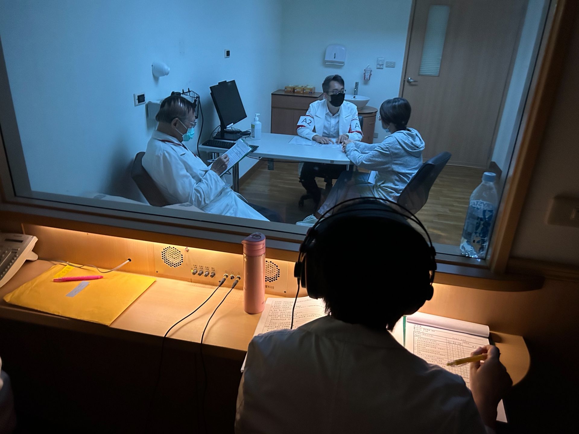 來自關山慈院的觀摩考官鄒牧帆醫師(右一)，仔細觀察考官與考生、標準化病人互動。