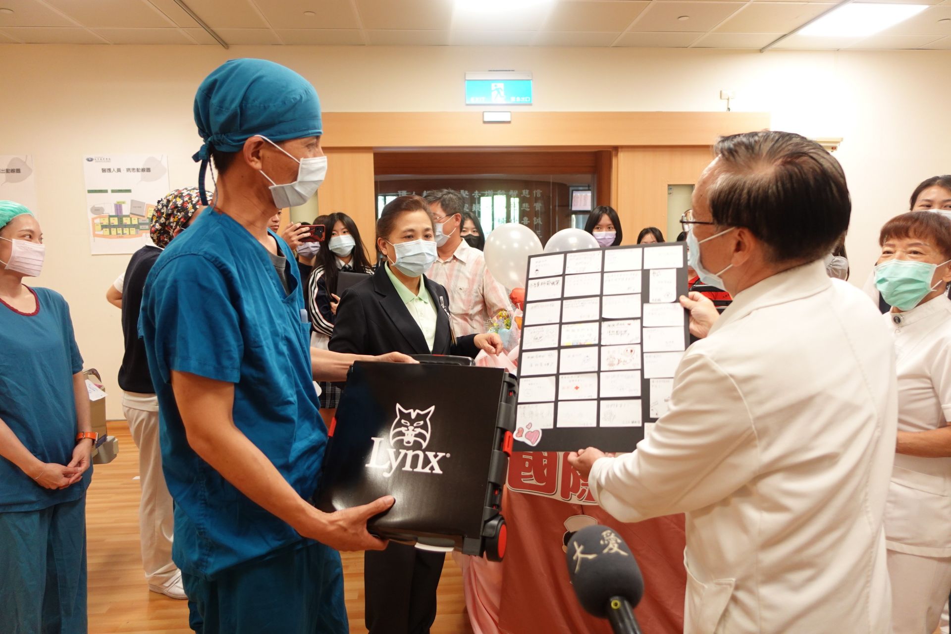 簡守信院長（右）帶來學生的感恩心意，讓開刀房副護理長劉文亮（左）深感護理人員的辛勞得到肯定。