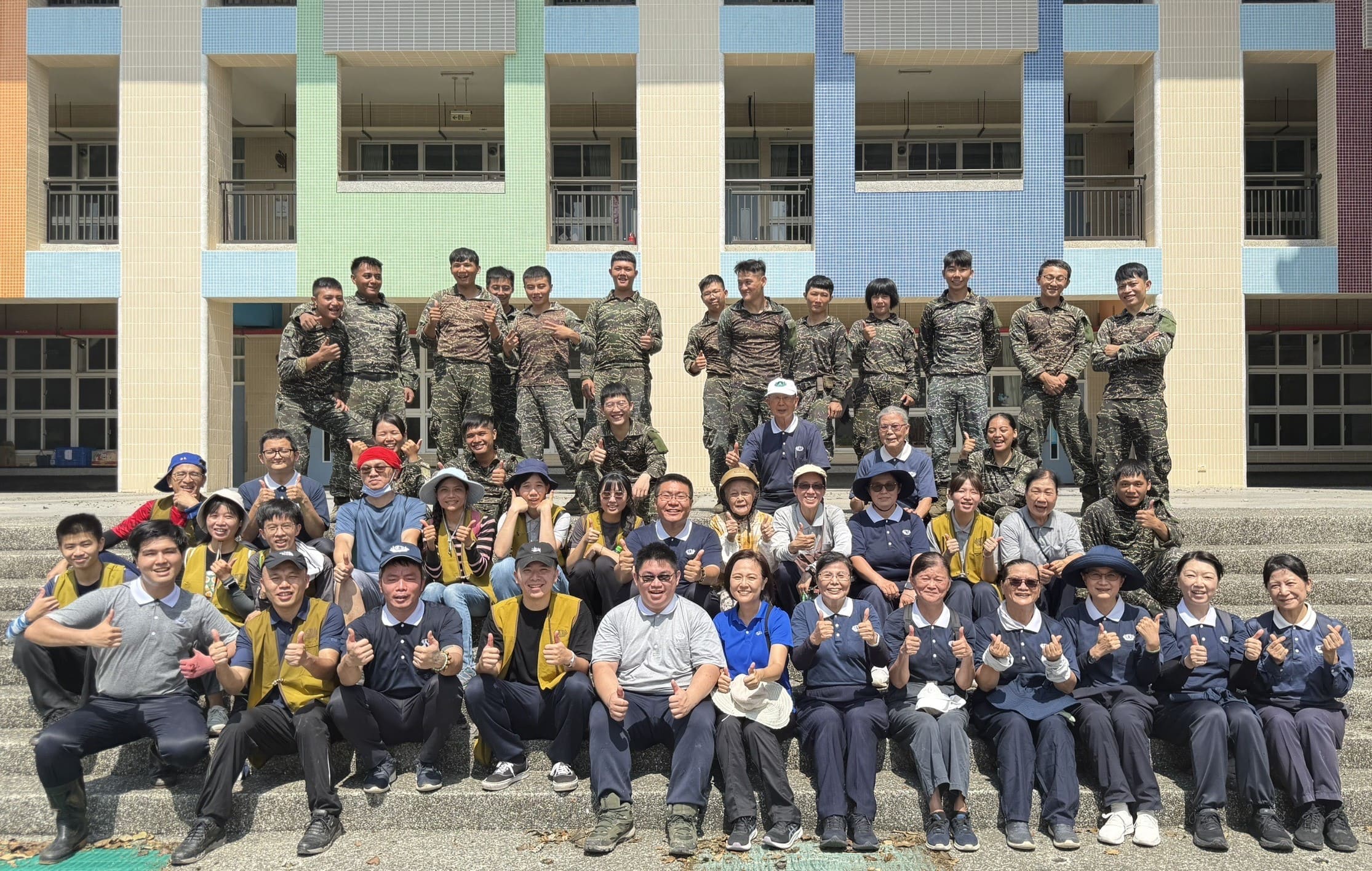 國軍官兵、慈濟志工及慈濟號召參與高屏災後復原的青年志工在完成校園清掃任務後，留下一幅難得的軍民與青年共善的合照