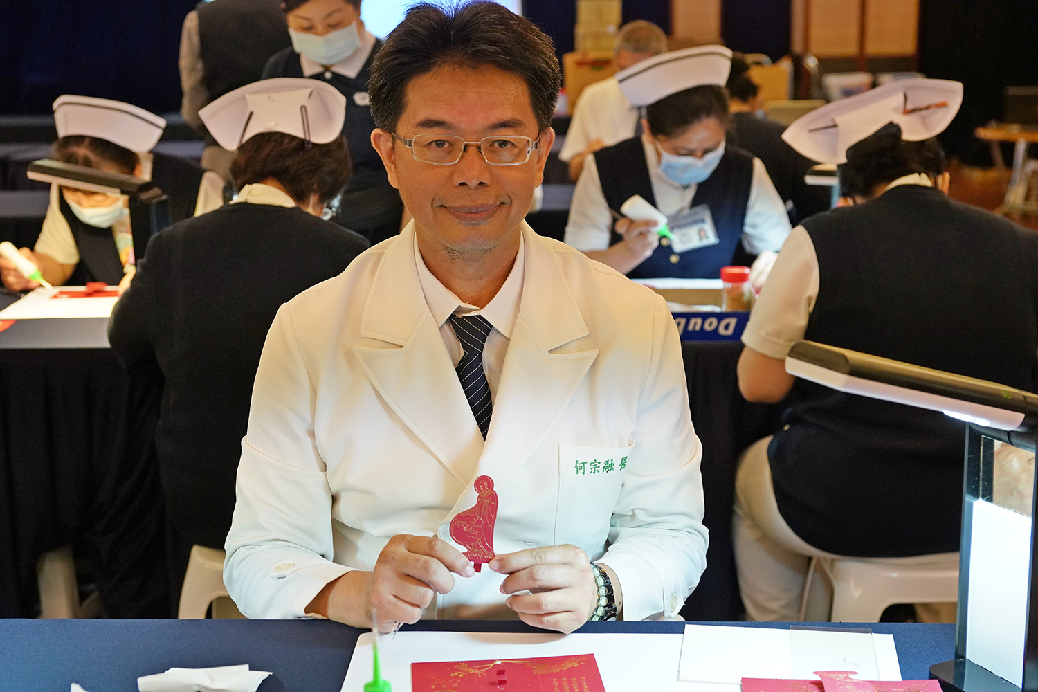 何宗融副院長，手持宇宙大覺者，親自參與福慧紅包製作。