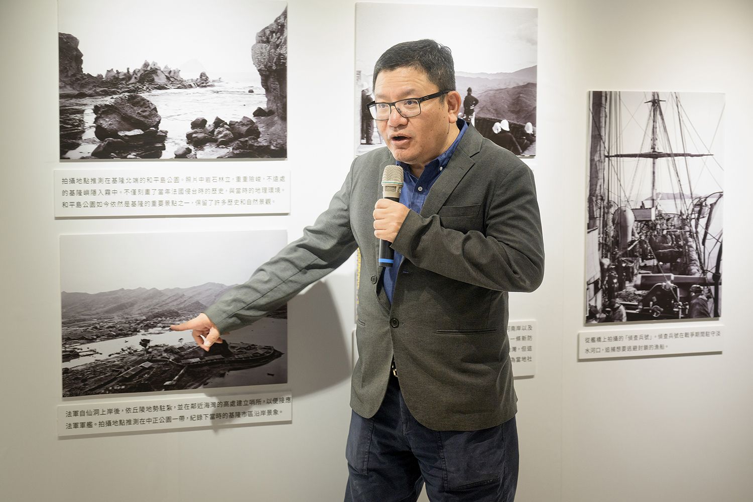 基隆市方定安秘書長藉由展覽中的昔日影像，向與會來賓指出慶安宮以前的位址所在。